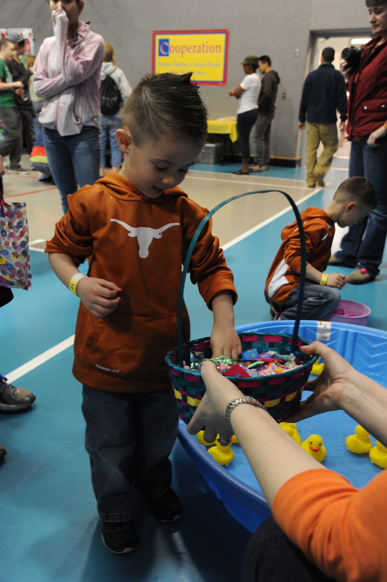 Travian, son of Tech. Sgts. Henry and Elizabeth Ayala, 819th RED HORSE Squadron members, reaches for a piece of candy after playing a game in the duck pond at the Spring Carnival at the Youth Center on March 30. Candy and toys were given to children of all ages during the annual event. (U.S. Air Force photo/Airman 1st Class Katrina Heikkinen)