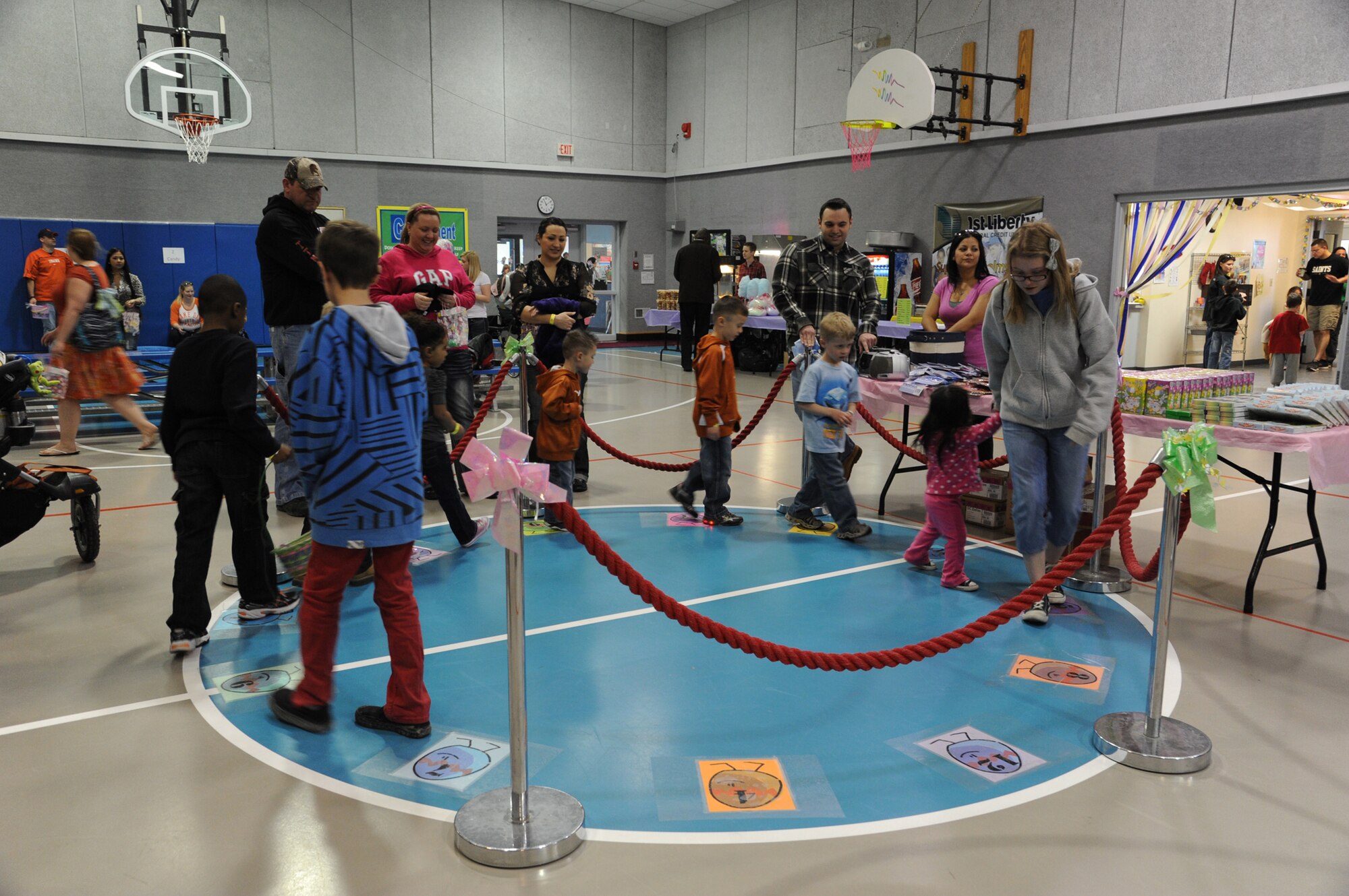 Children of all ages walk around a circle at the prize walk station during the annual Spring Carnival at the Youth Center on March 30. Members of Team Malmstrom volunteered at the event. (U.S. Air Force photo/Airman 1st Class Katrina Heikkinen)