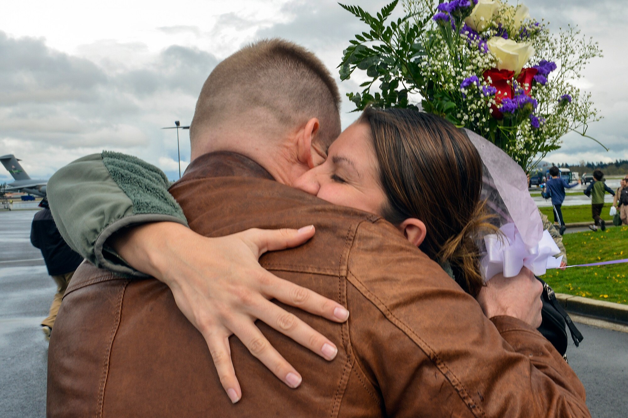 1st Lt. Jessica Hillard, 62nd Operations Support Squadron intelligence officer, is embraced by her husband Steven upon returning home from a deployment to Southwest Asia, April 5, 2013, at Joint Base Lewis-McChord, Wash. Hillard deployed as part of the 817th Expeditionary Airlift Squadron, which is tasked with providing C-17 airlift in support of Operation Enduring Freedom. (U.S. Air Force photo/Airman 1st Class Jacob Jimenez)