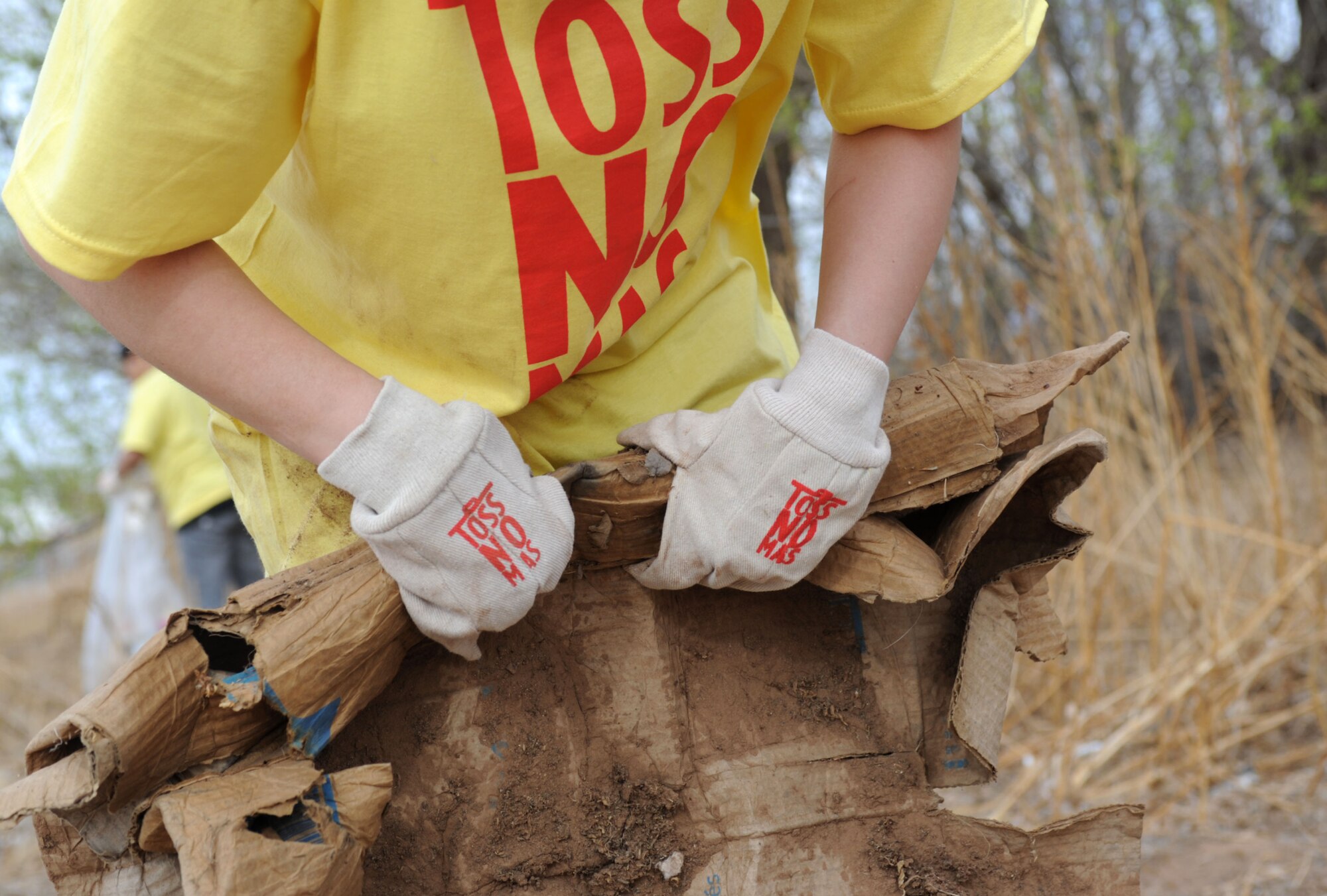 U.S. Air Force Airman 1st Class Christina Burklow, 27th Special Operations Communication’s Squadron, cyber security technician, picks up litter at the annual Great American Clean Up in Clovis N.M., April 6, 2013. More than 150 volunteers from Cannon Air Force Base joined with volunteers from the community to clean up the streets of Clovis. (U.S. Air Force photo/Airman 1st Class Ericka Engblom)