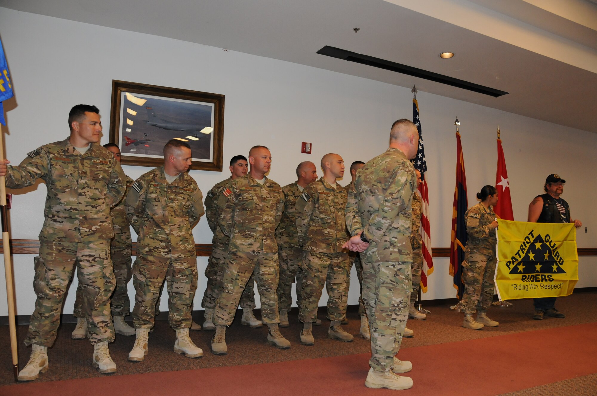 The Patriot Guard Riders present a flag to deploying members of the 161st Security Forces Squadron, during a send-off ceremony April 6, 2013. The Patriot Guard Riders is a motorcycle club whose members recognize and honor the sacrifices of U.S. Service members, firefighters and police officers and their families. (Air National Guard photo by Tech. Sgt. Susan Gladstein/Released)
