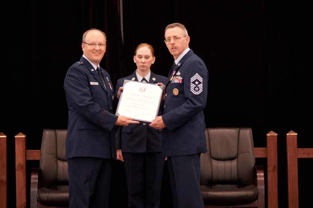 Brig. Gen. Travis D. Balch, Arkansas Air National Guard commander, presents Command Chief Master Sgt. Stephen W. Arnold, former Arkansas Air National Guard command chief, his Certificate of Retirement at Hangar 207 on April 7, 2013.