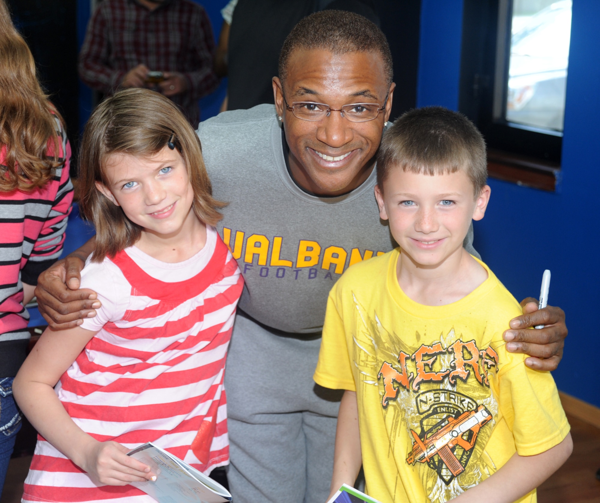 Comedian Tommy Davidson takes a photo with two children during an autograph session at the Youth Center April 5, 2013, at Incirlik Air Base, Turkey. Davidson, along with fellow comedian Alexe Liss, toured the base and signed autographs as part of an Armed Forces Entertainment event. (U.S. Air Force photo by Staff Sgt. Eric Summers Jr./Released)