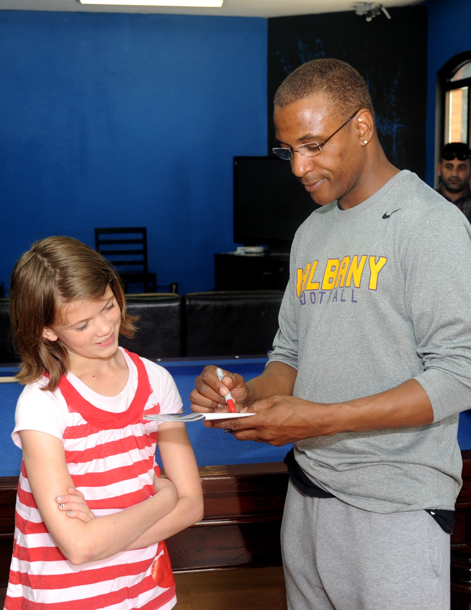 Comedian Tommy Davidson signs an autograph for a young fan during a meet and greet at the Youth Center, April 5, 2013, at Incirlik Air Base, Turkey. Davidson, accompanied by Alexe Liss, performed a comedy show at the Club Complex and met with Airmen and their families around base. (U.S. Air Force photo by Staff Sgt. Eric Summers Jr./Released)