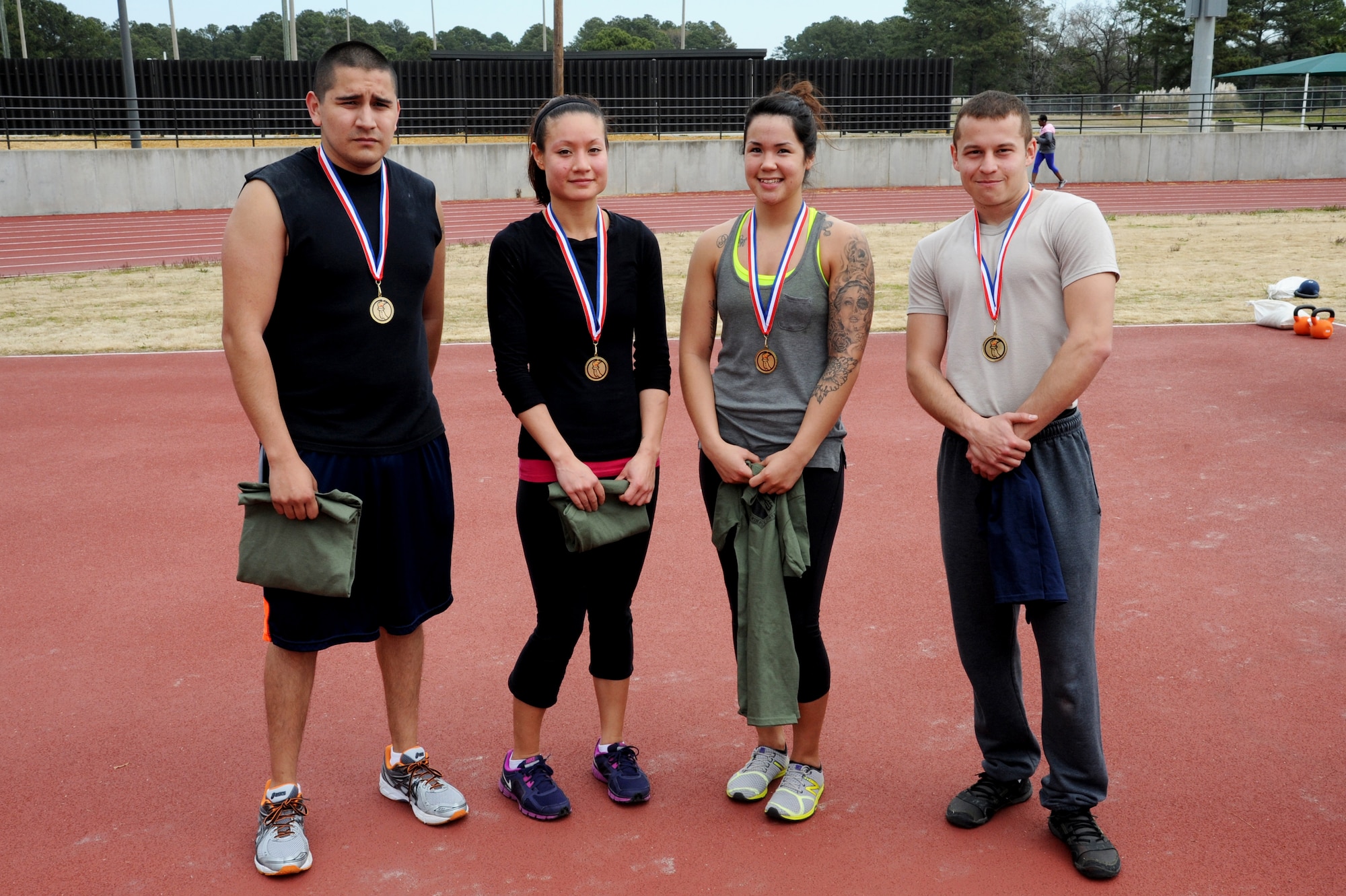 From the left, U.S. Air Force Senior Airman Marc Fuentes, 4th Equipment Maintenance Squadron aircraft structural maintenance technician, Jackie Pedraza, spouse of Airman 1st Class Juan Pedraza, 4th Fighter Wing Command Post emergency actions controller, Senior Airman Melissa Perkins, 4th Force Support Squadron services journeyman, and Airman 1st Class Jordan Melendez, 4th Aircraft Maintenance Squadron avionics technician, pose after receiving their medals for having the fastest times in the Combat Fitness Challenge at the fitness center track on Seymour Johnson Air Force Base, N.C., March 30, 2013.  Melendez was the overall winner, followed by Fuentes; Perkins and Pedraza were the first and second place female competitors, respectively.  (U.S. Air Force photo by Airman 1st Class Brittain Crolley/Released)
