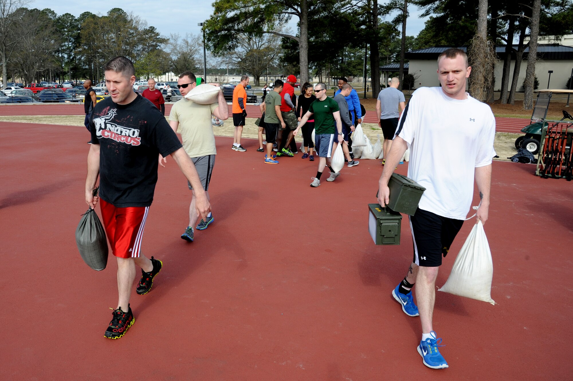 Combat Fitness Challenge participants help setup obstacles before beginning the competition held at the fitness center track on Seymour Johnson Air Force Base, N.C., March 30, 2013.  Some of the challenges included a 100-meter dash while performing a fireman’s carry with a sandbag and a 100-meter dash while carrying two ammo cans full of water. (U.S. Air Force photo by Airman 1st Class Brittain Crolley/Released)