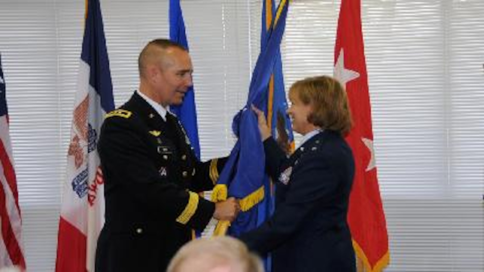 Maj. Gen. Tim Orr, adjutant general of the Iowa National Guard, presents a general officer flag to Brig. Gen. Jennifer Walter at her promotion ceremony to Brigadier General on Oct. 14 in Des Moines. Walter is the first female general officer in the history of the Iowa Air National Guard.