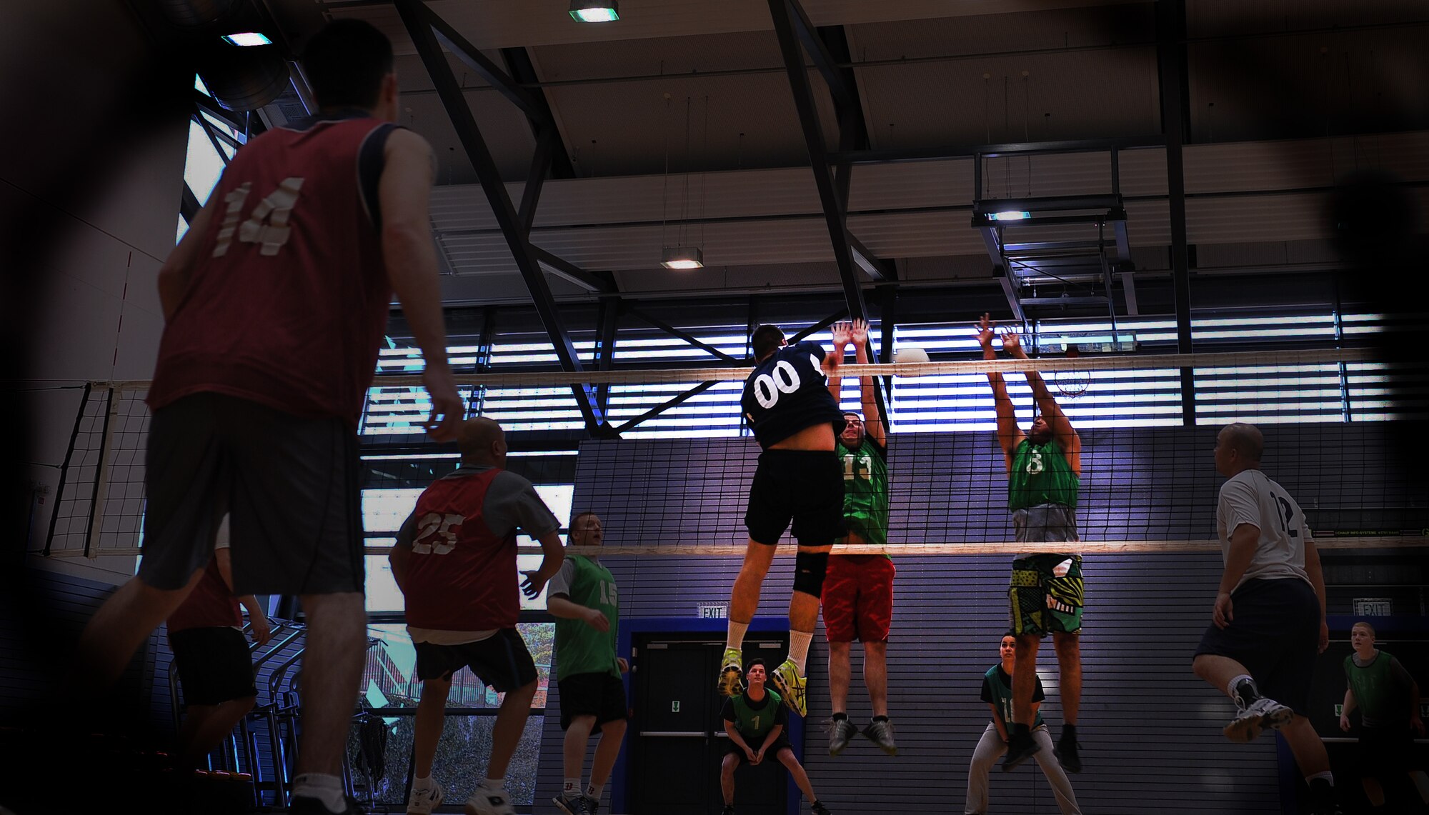 Airmen from the 86th Munitions Squadron and the 21st Operations Weather Squadron play in an intramural volleyball match at the Southside Fitness Center April 3, 2013, Ramstein Air Base, Germany. Intramural sports offer Airmen the opportunity to develop team-building skills, work on physical fitness and allow coworkers to spend time together away from work. The volleyball season runs until the end of May, where two out of 10 teams from each league will compete in a tournament to see who will meet in a classic East vs. West matchup for the base championship. Other intramural sports include soccer, softball and flag football, which are played throughout the year. (U.S. Air Force photo illustration/Airman 1st Class Dymekre Allen) 