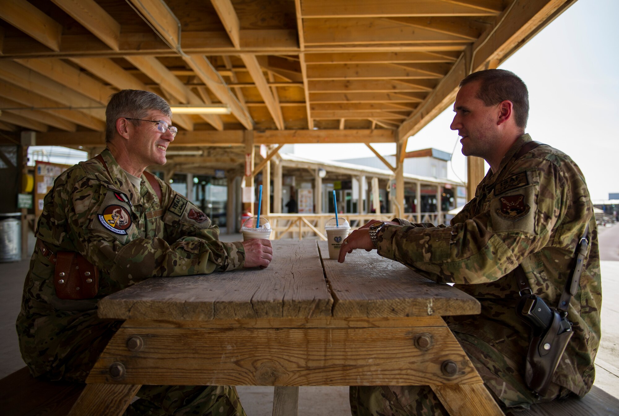 Capt. Justin, left, 361st Expeditionary Reconnaissance Squadron chief of scheduling, and Lt. Col. Robert, right, 62nd ERS remotely piloted aircraft pilot, sit together, March 4, 2013, on Kandahar Airfield, Afghanistan. Robert is deployed at the same time to the same location as his son, Justin. (U.S. Air Force photo by Staff Sgt. Marleah Miller)
