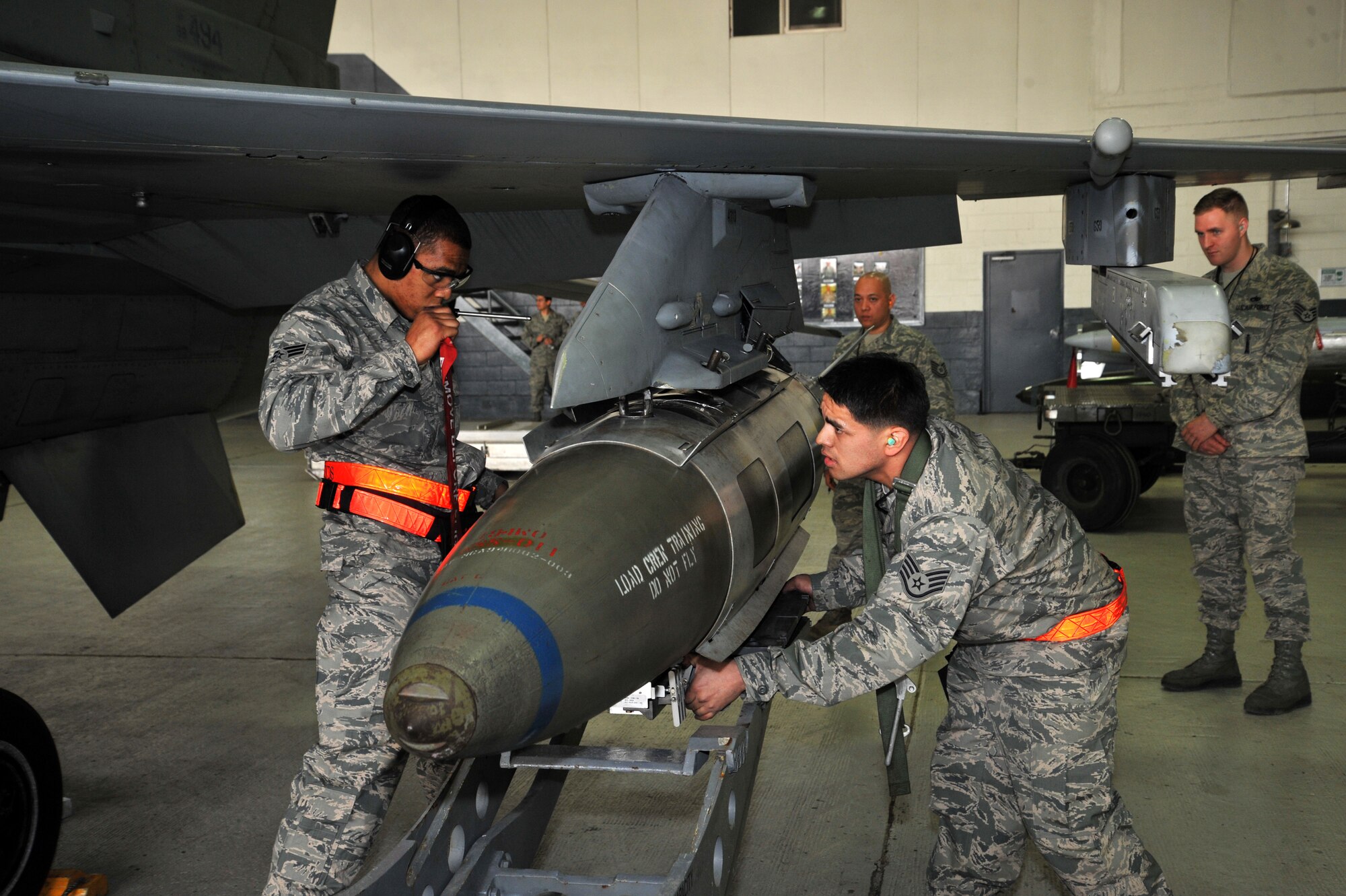 Senior Airman Dwight Hunter (left) and Staff Sgt. Jose Morin, 36th Aircraft Maintenance Unit weapons loaders, secure a GBU-31 bomb on an F-16 Fighting Falcon during the quarterly weapons load crew competition at Osan Air Base, Republic of Korea, April 5, 2013.  As part of the competition, Airmen are inspected on their dress and appearance and given a written examination as well.   (U.S. Air Force photo/Staff Sgt. Emerson Nuñez)