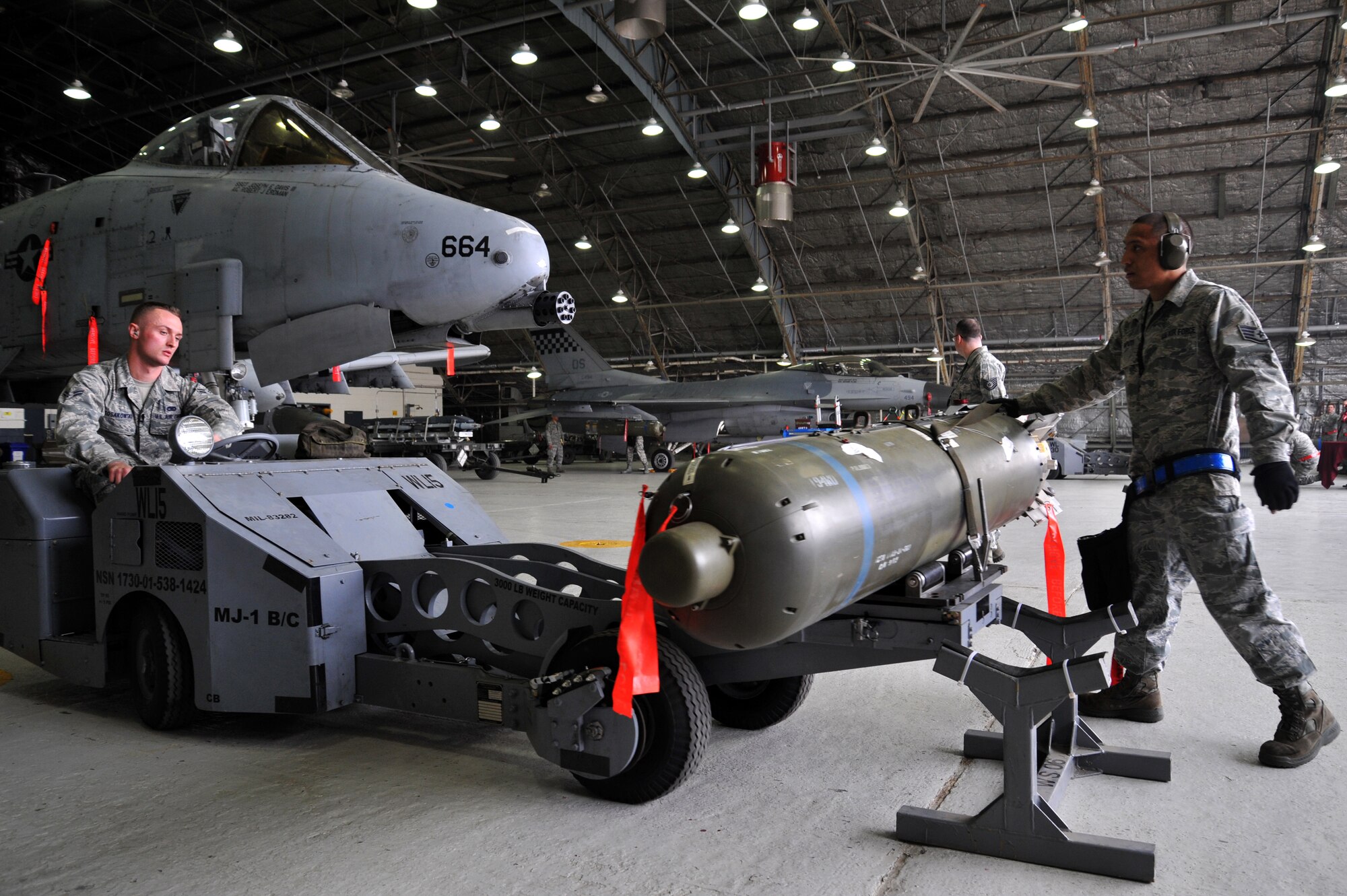 Airman 1st Class Nikolaus Kosakowski, left, and Staff Sgt. Ryan Naputi, 25th Aircraft Maintenance Unit weapons loaders, prepare to lift a CBU-103 bomb to load to an F-16 Fighting Falcon during the quarterly weapons load crew competition at Osan Air Base, Republic of Korea, April 5, 2013.  In order for the load crews to earn their place in the competition, they must prove themselves during their monthly proficiency loads, quarterly evaluations and every day mission. (U.S. Air Force photo/Staff Sgt. Emerson Nuñez)