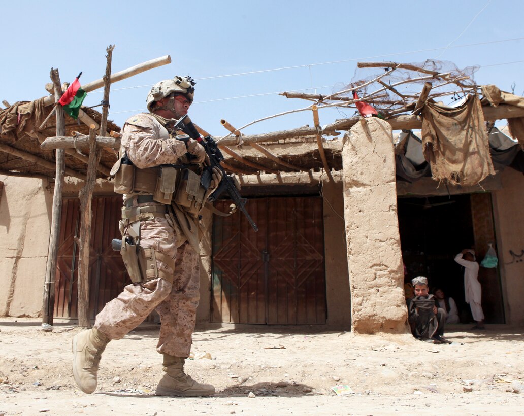 U.S. Marine Corps Sgt. Benito Serrano patrols though the bazaar near the Afghan Uniform Police Outpost Mamuriyet near Kajaki district in Afghanistan's Helmand province, April 1, 2013. Serrano is assigned to the U.S. Marine-led Kajaki Police Advisor Team.