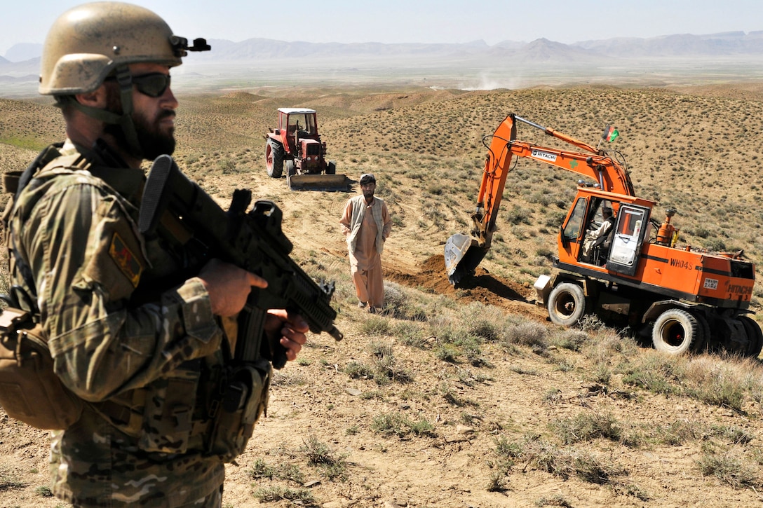 An Albanian special operations forces soldier provides security as Afghan border police break ground on a checkpoint near the Afghanistan-Pakistan border in the Spin Boldak district of Afghanistan’s Kandahar province, March 25, 2013. The checkpoint was being built to block an insurgent infiltration route.