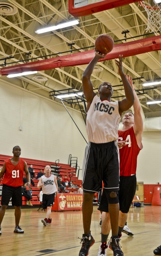 Jelani Nix, head coach, Marine Corps System Command intramural basketball team, has no problem getting around his opponents for a layup during a game against the Naval Health Clinic team at the Barber Physical Activity Center on April 4, 2013. With only five players, the NHC was not able substitute and fatigue plagued the team late in the first half. 