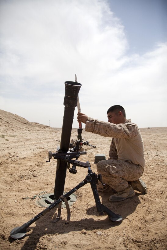 U.S. Marine Corps Lance Cpl. Edward Amores, a mortarman assigned to Weapons Company, 3rd Battalion, 9th Marine Regiment (3/9), confirms the correct alignment of a M252 81 mm mortar system while setting up a gun position on forward operating base Payne, Helmand province, Afghanistan, April 3, 2013. The Marines of 3/9 prepared to conduct a night fire mission in order to disrupt enemy activity. (U.S. Marine Corps photo by Cpl. Alejandro Pena/Released)   
