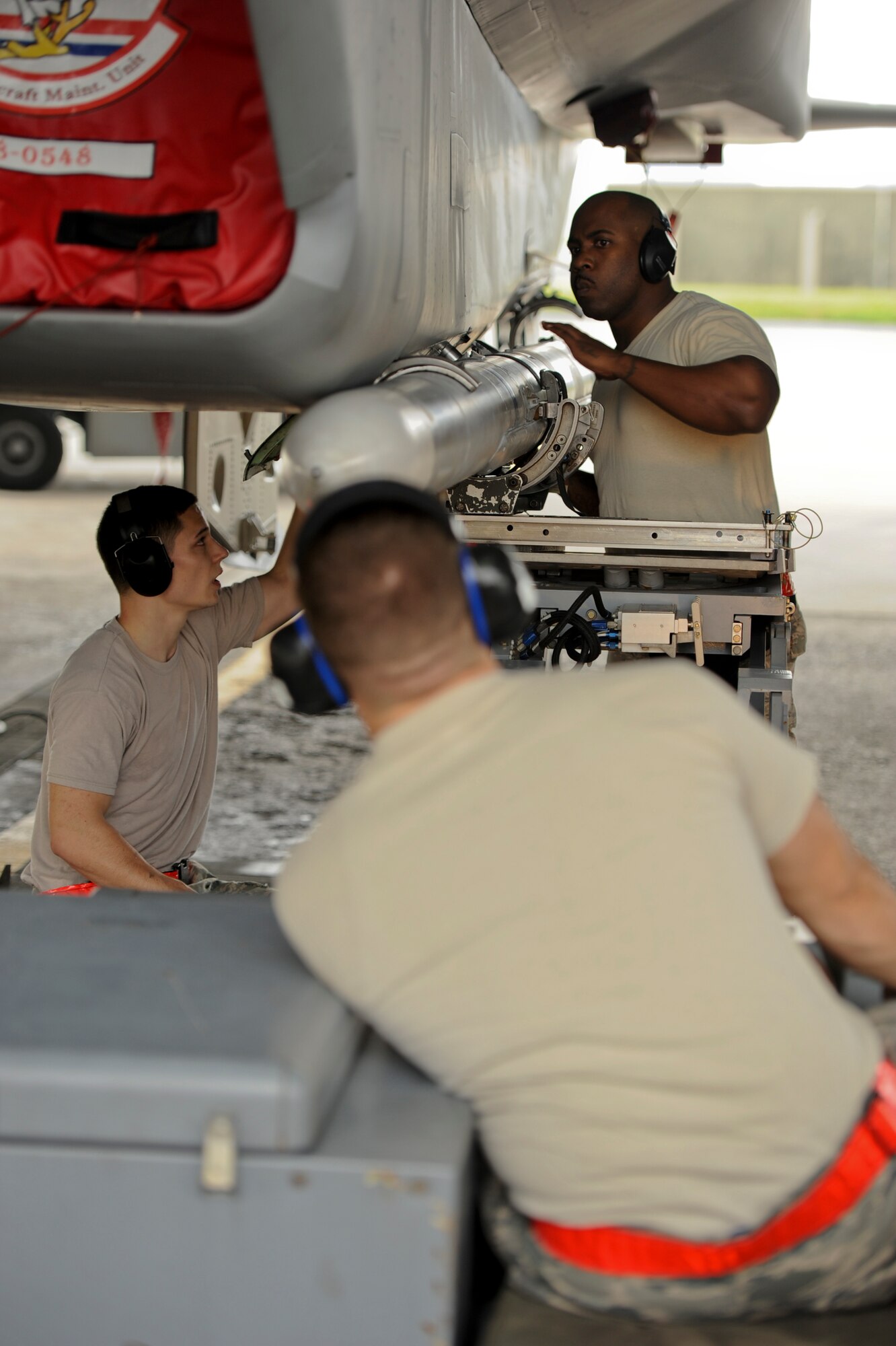 Members of the 67th Aircraft Maintenance Unit ensure a training missile is secured correctly during a weapons load competition on Kadena Air Base, Japan, April 5, 2013. Competitions like these allow load crews to be recognized and provide people an opportunity to come out and see what they do on a daily basis. (U.S. Air Force photo by Airman 1st Class Justin Veazie)
