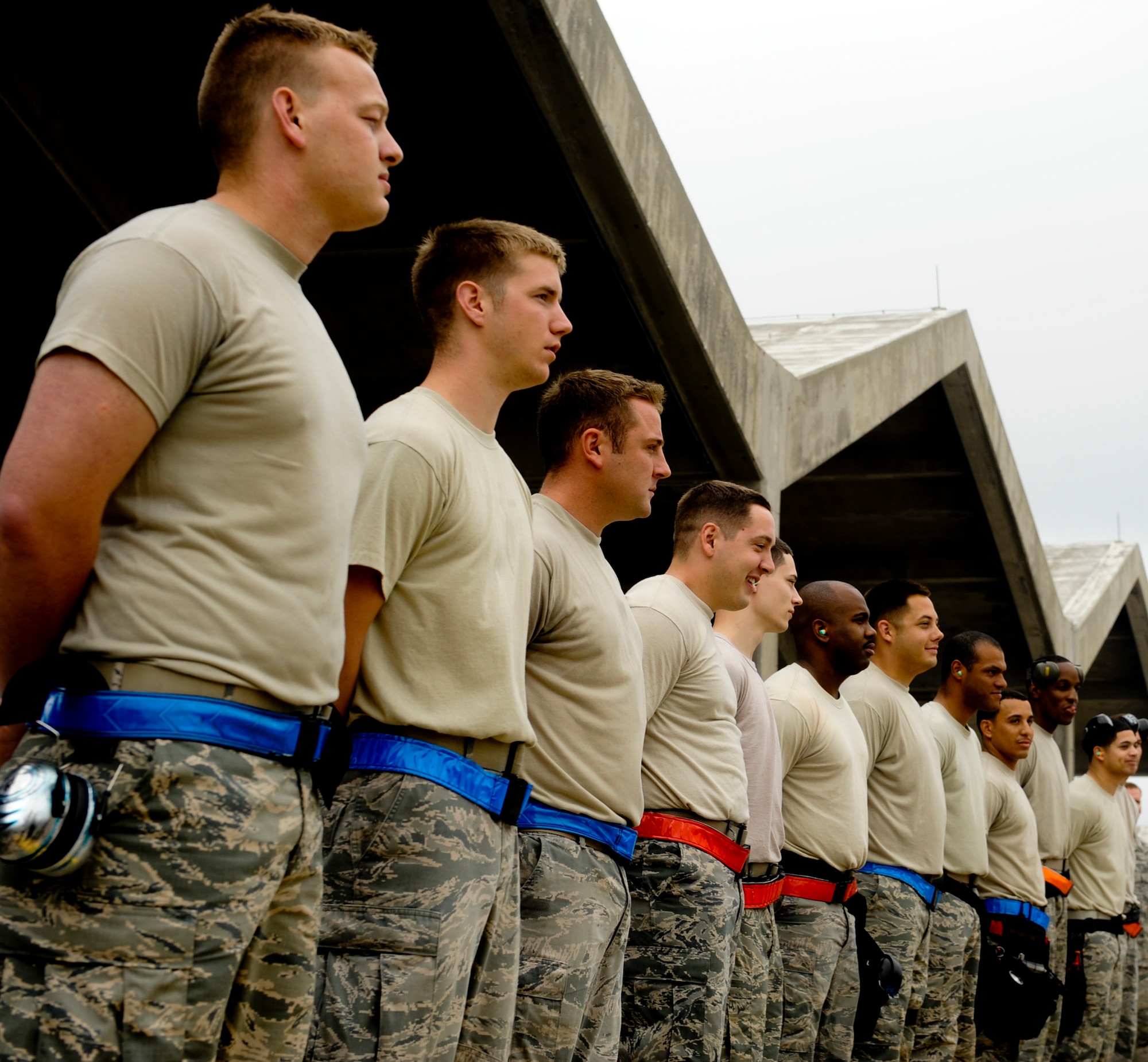 U.S. Air Force Airmen stand at parade rest during the opening remarks of a weapons load competition on Kadena Air Base, Japan, April 5, 2013. Competitions like these allow load crews to be recognized and provide people an opportunity to come out and see what they do on a daily basis. (U.S. Air Force photo by Airman 1st Class Justin Veazie)