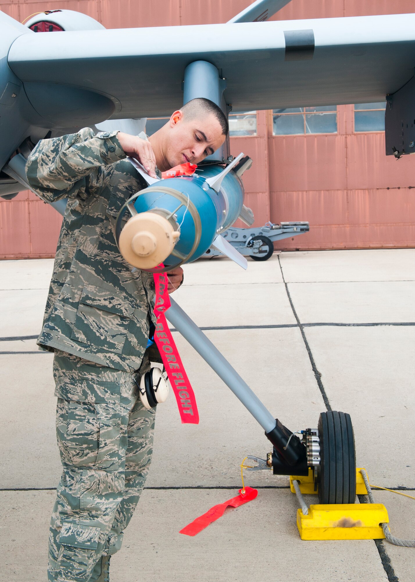 Staff Sgt. Jonathan Adams, 849th Aircraft Maintenance Squadron, checks an inert missile loaded onto an MQ-9 Reaper aircraft during a quarterly load-crew competition at Holloman Air Force Base, N.M., April 5. The MQ-9 load-crew competed in the competition to have their skills evaluated alongside the F-22 Raptor aircraft and German Air Force load-crews. For the competition, points are awarded during the weapons-loading, tool kit inspection, and uniform inspection. (U.S. Air Force photo by Airman 1st Class Leah Murray/Released)