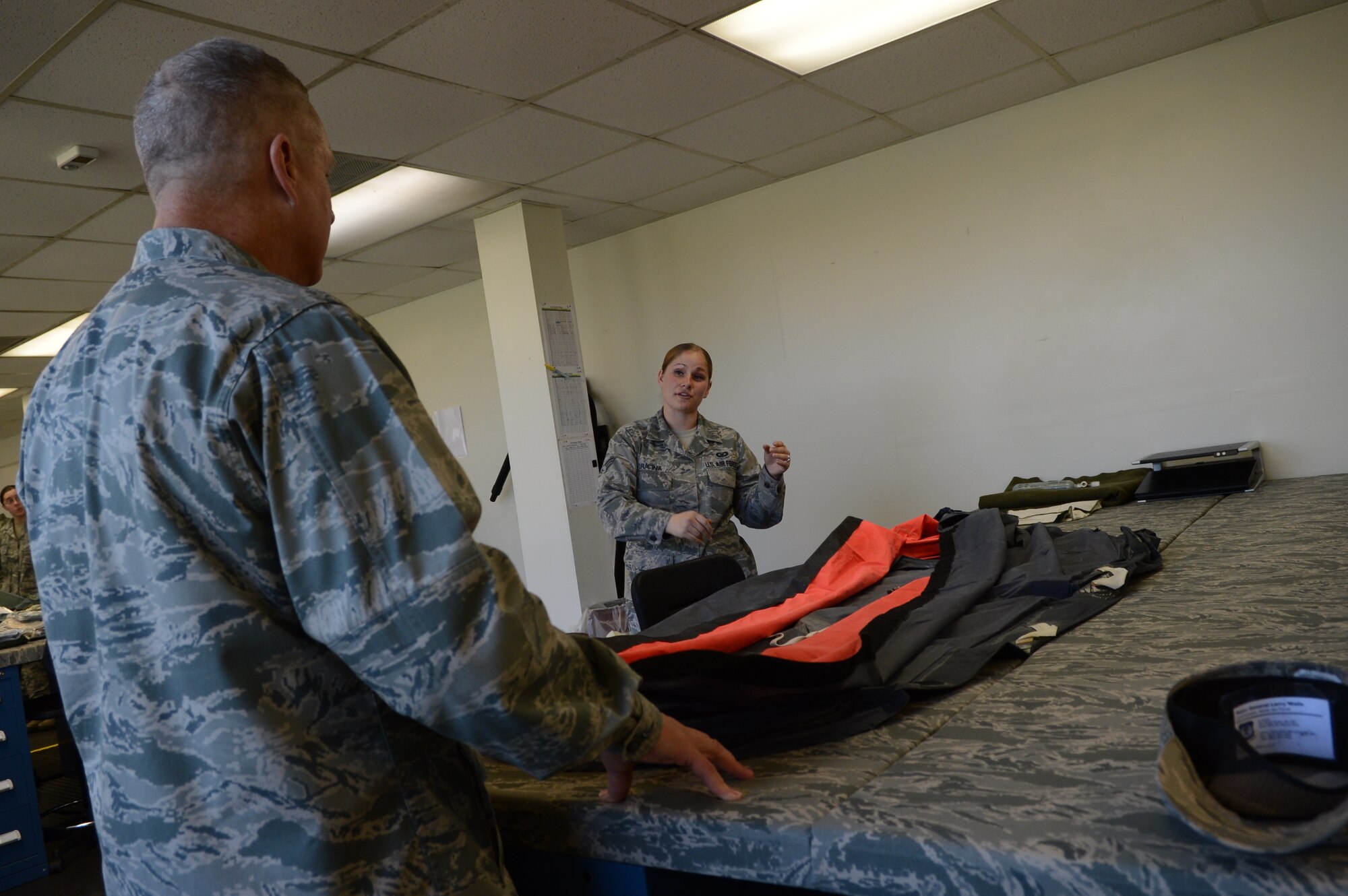 U.S. Air Force Senior Airman Leigh Fucina, 20th Operational Support Squadron aircrew flight equipment technician explains the procedures of inflating a one man life raft during the 9th Air Force leadership visit at Shaw Air Force Base, S.C., April 9, 2013.  Maj. Gen. Lawrence Wells, 9th Air Force commander and Chief Master Sgt. James Davis, 9th Air Force command chief visited different squadrons at Shaw for the last time before Wells’ retirement. (U.S. Air Force photo by Airman 1st Class Nicole Sikorski/Released)