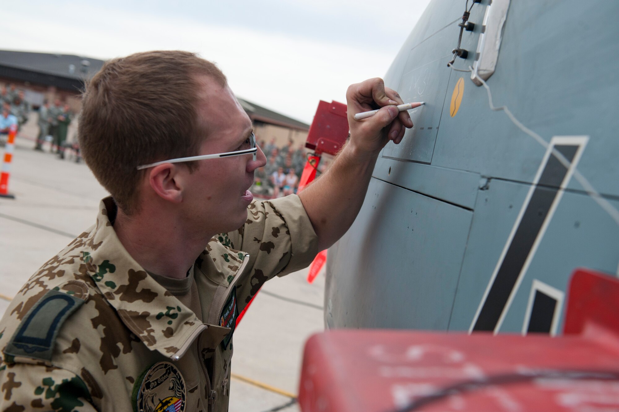 Staff Sgt. Frank Schwetzler, German Air Force Flying Training Center crew chief, writes pertinent information onto the airframe of a Tornado jet aircraft during a quarterly load-crew competition at Holloman Air Force Base, N.M., April 5. The GAF competed in the load-crew competition to have their skills evaluated alongside the F-22 Raptor aircraft and MQ-9 Reaper aircraft load-crews. For the competition, points are awarded during the weapons-loading, tool kit inspection, and uniform inspection. (U.S. Air Force photo by Airman First Class Daniel Liddicoet/Released)