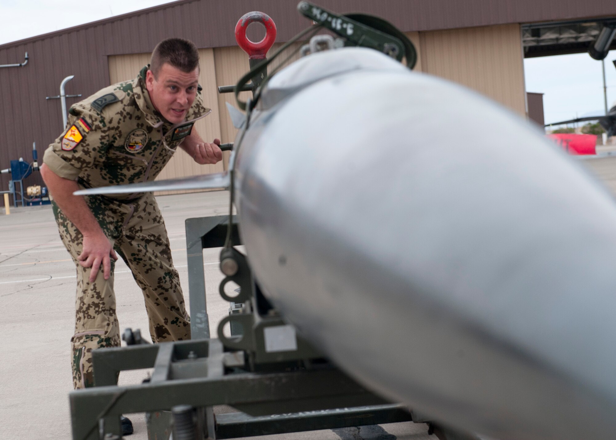Technical Sgt. Stefan Hoppe, German Air Force Flying Training Center crew chief, raises an inert missile up to be loaded onto a Tornado jet aircraft during a quarterly load-crew competition at Holloman Air Force Base, N.M., April 5. The GAF competed in the load-crew competition to have their skills evaluated alongside the F-22 Raptor aircraft and MQ-9 Reaper aircraft load-crews. For the competition, points are awarded during the weapons-loading, tool kit inspection, and uniform inspection. (U.S. Air Force photo by Airman First Class Daniel Liddicoet/Released)