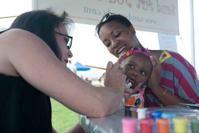 Janiyah Charles, daughter of Staff Sgt. Ashley Charles, 99th Force Support Squadron fitness specialist, gets her face painted by a volunteer April 6, 2013, at the Nellis Youth Center in celebration of Military Child Appreciation Day. The 99th FSS hosted the day to provide an opportunity for military children to interact with Airmen from different career fields and to see the importance of what their parents do in the Air Force. Military children were also treated to an array of events including a sack race, water balloon throwing contest and a sumo wrestling contest.  (Air Force photo by Staff Sgt. Michael Charles)