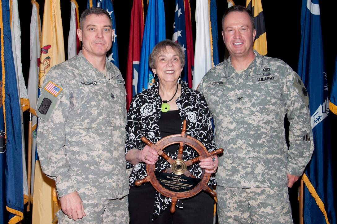 Command Sgt. Maj. Kevin Blasko, 597th Transportation Brigade command sergeant major, and Col. Charles R. Brown, 597th Trans. Bde. commander, present Berna Heyman (center) a plaque during the 2013 Holocaust Days of Remembrance at Jacobs Theater on Fort Eustis, Va., 9 April 2013. Heyman was the guest speaker at the event, hosted by the 597th Trans. Bde. to honor victims of the Holocaust. (U.S. Air Force photo by Tech. Sgt. April Wickes/Released) 