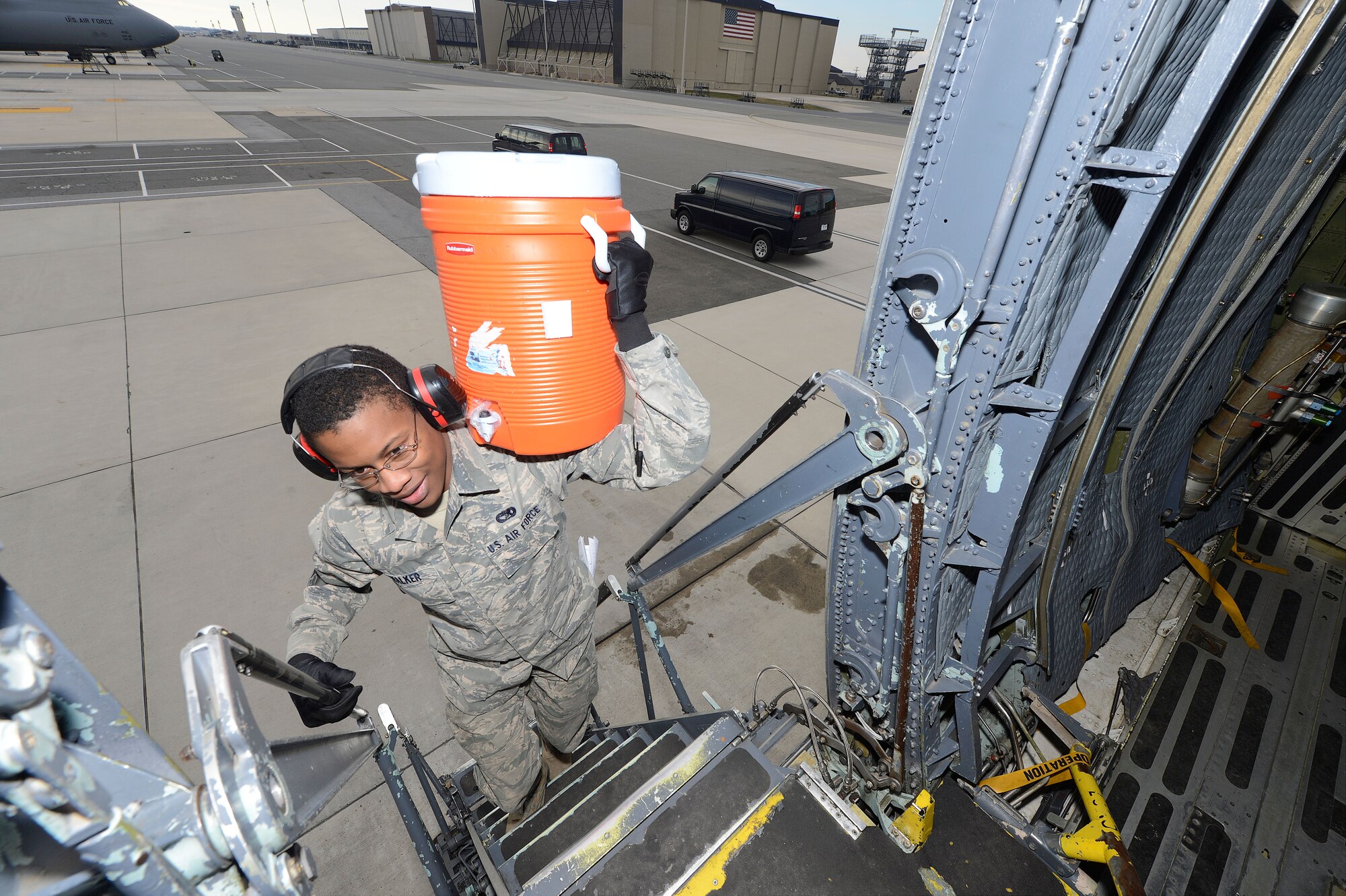 Airman 1st Class Brandon Walker carries a insulated water container up the main crew entry ladder of a C-5M Super Galaxy from the 436th Airlift Wing, Dover Air Force Base, Del., March 28, 2013, as the aircraft is prepared for a flight overseas. The 436th Aerial Port Squadron, clean fleet services section, provides comfort items such as potable water, pillows and blankets and other items needed by aircrew and passengers. (U.S. Air Force photo/Greg L. Davis)
