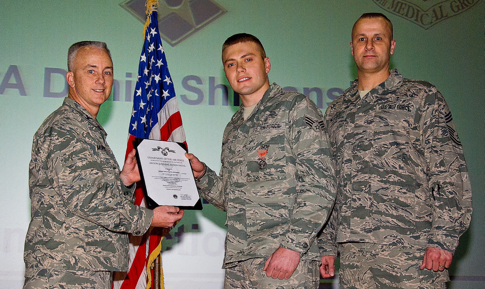 Senior Airman Daniel Shimanski, 436th Medical Operations Squadron emergency medical technician, receives the Air Force Combat Action Medal April 5, 2013, at the base theater on Dover Air Force Base, Del. The AFCAM, which is awarded to people who are actively engaged in lethal fire or are being engaged, is actually a rare award for medics to receive since most of them only deploy to the hospitals down range. (U.S. Air Force photo/Senior Airman Jared Duhon)
