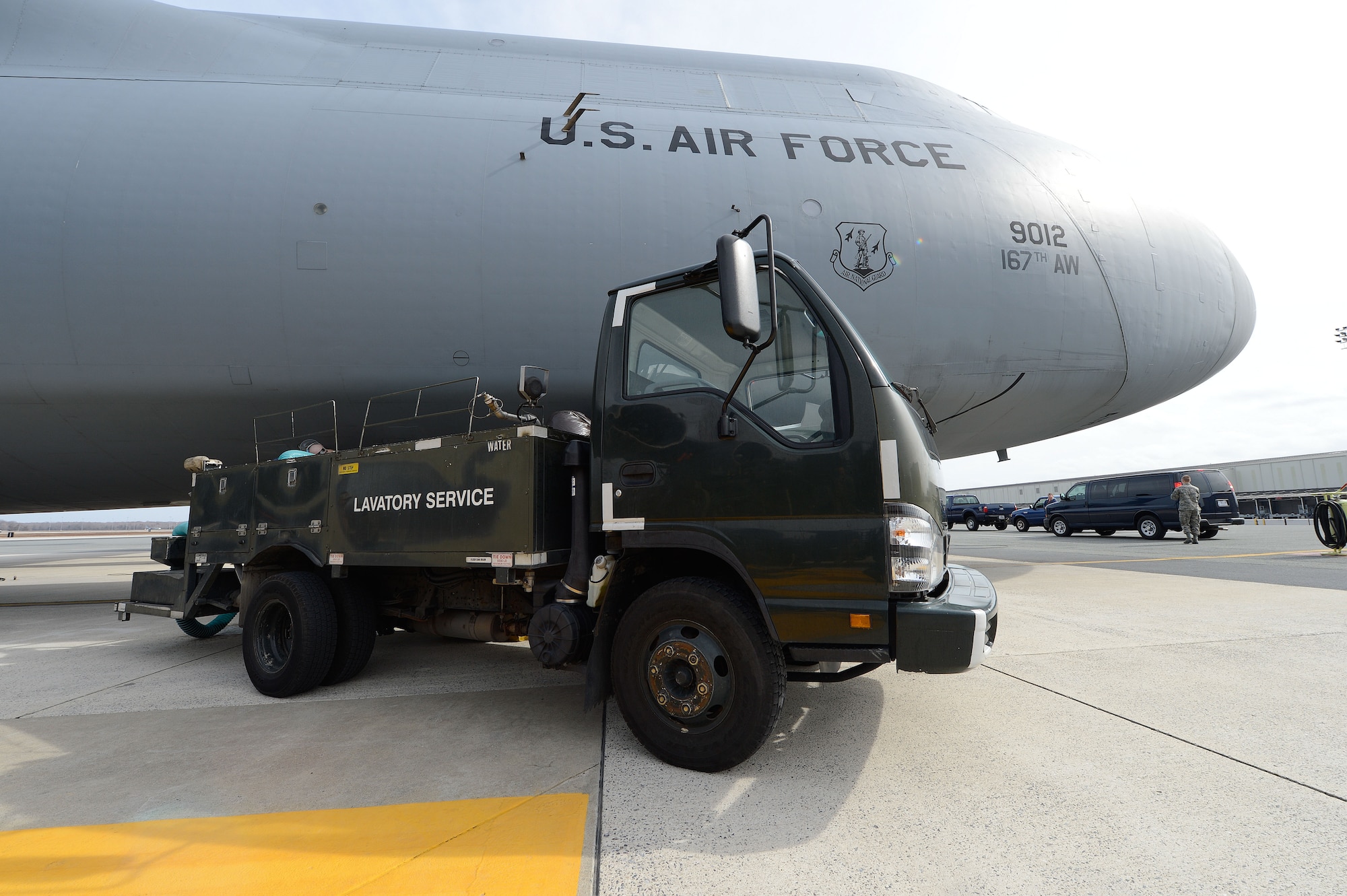 Airman 1st Class Robert Stemmler, left, receives personal protective equipment from A1C Eric Hastings as they prepare to provide fleet service to a C-5A Galaxy immediately after landing, March 11, 2013, Dover Air Force Base, Del. The C-5A Galaxy from the 167th Airlift Wing, West Virginia Air National Guard, has just returned from a mission overseas and will be fully serviced and quickly returnd to service by the professionals of the the 436th Aerial Port Squadron, fleet services section. (U.S. Air Force photo/Greg L. Davis)