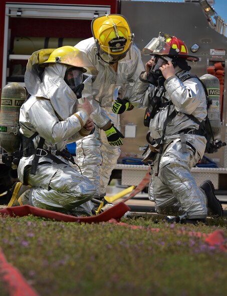 During a major accident response exercise on April 6th, 2013 firefighters don protective gear prior to entering a simulated building fire to search for casualties and assess tornado damage at the 138th Fighter Wing in Tulsa, Oklahoma.  The exercise was conducted to measure the response of installation emergency personnel as well as observe and insure that the base populous took appropriate action.  (U. S. Air Force photo/Master Sgt.  Mark A. Moore) 