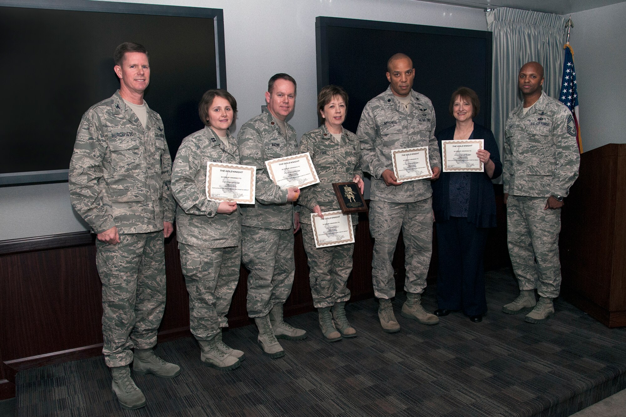 Col. Richard Burchfield (left), 21st individual mobilization augmentee to the 21st Space Wing commander, and Chief Master Sgt. Lavon Coles, 21st Operations Group chief, present the Gold Knight award to the 21st Medical Group National Committee for Quality Assurance Accreditation preparation team. (U.S. Air Force photo/Craig Denton)