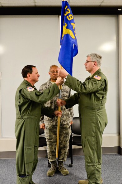 Col. Mike Pankau, 139th Airlift Wing commander, hands the 139th Medical Group flag to Col. Terry Hall, 139th Medical Group chief of aerospace medicine, at Rosecrans Air National Guard Base, St. Joseph, Mo., April 7, 2013. Hall became the new commander of the group during an assumption of command ceremony. (Air National Guard photo by Tech. Sgt. Michael Crane/Released)