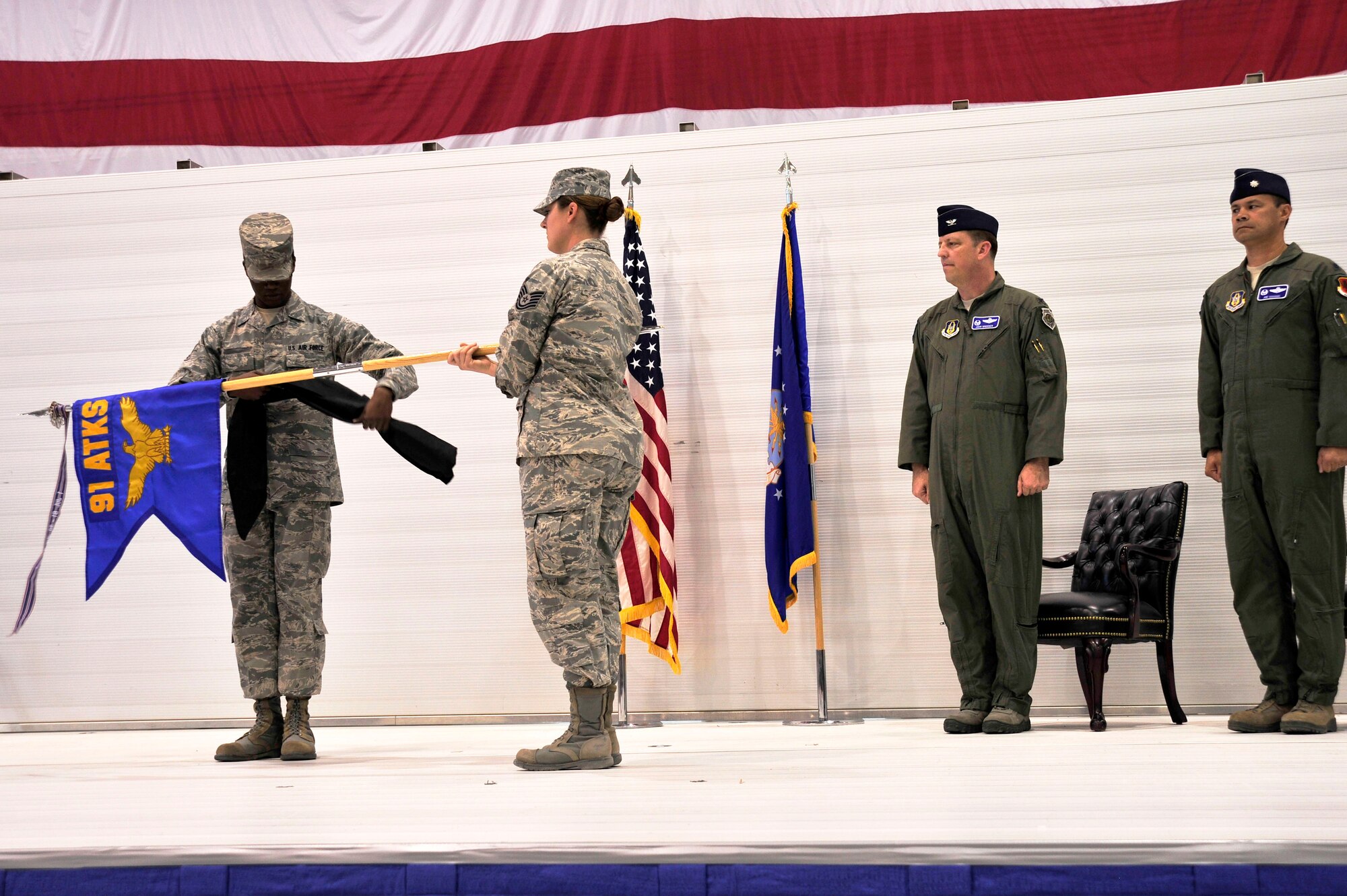 LAS VEGAS, Nev. – The 91st Attack Squadron acting first sergeant and members of the ceremonial team unfurl the 91st ATKS guidon during the squadron’s activation ceremony April 5, 2013. The squadron flies MQ-1B Predator and MQ-9 Reaper remotely piloted aircraft in support of national strategy. (U.S. Air Force photo by Senior Master Sgt. P.H.)
