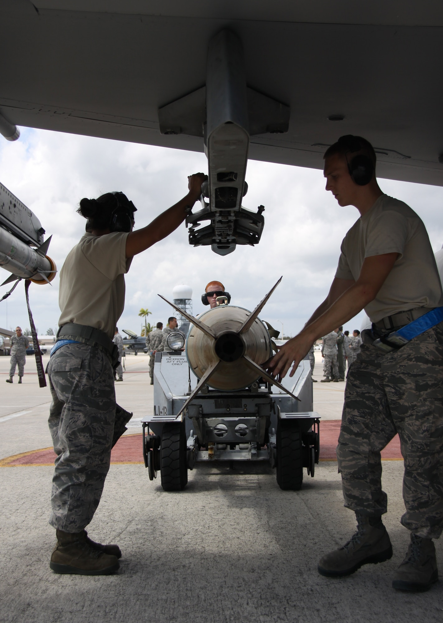 From left: Staff Sgt. Danessa Gali, Airman 1st Class William Ford, and Senior Airman Stephen Hoffler,  all of the 495th Fighter Group, Detachment 93, prepare to load a bomb onto an F-16 during the 482nd Aircraft Maintenance Squadron’s Quarterly Load Crew Competition at Homestead Air Reserve Base, Fla., April 7. The load crews were evaluated in four areas to determine the winner: dress and personal appearance, tool kit inspection, a general knowledge test, and actual munitions loading to include speed and proficiency. (U.S. Air Force photo/Tech. Sgt. Leo Castellano)