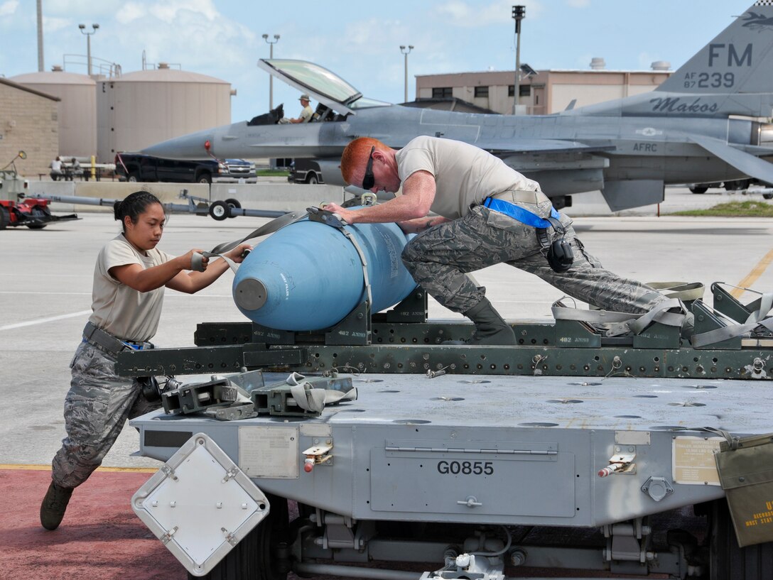 Staff Sgt. Danessa Gali and Airman 1st Class William Ford, both of the 495th Fighter Group, Detachment 93, prepare to load a bomb onto an F-16 during the 482nd Aircraft Maintenance Squadron’s Quarterly Load Crew Competition at Homestead Air Reserve Base, Fla., April 7. The load crews were evaluated in four areas to determine the winner: dress and personal appearance, tool kit inspection, a general knowledge test, and actual munitions loading to include speed and proficiency. (U.S. Air Force photo/Senior Airman Nicholas Caceres) 