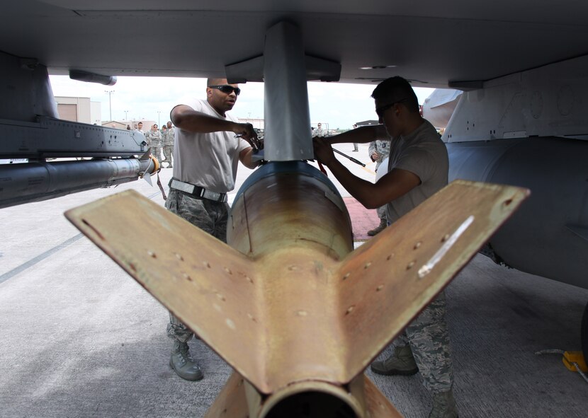 Senior Airman Melvin Bazan and Tech. Sgt. Desmond Allen, both of the 482nd Aircraft Maintenance Squadron, load a bomb onto an F-16 during the 482nd AMXS’s Quarterly Load Crew Competition at Homestead Air Reserve Base, Fla., April 7. The load crews were evaluated in four areas to determine the winner: dress and personal appearance, tool kit inspection, a general knowledge test, and actual munitions loading to include speed and proficiency. (U.S. Air Force photo/Tech. Sgt. Leo Castellano)