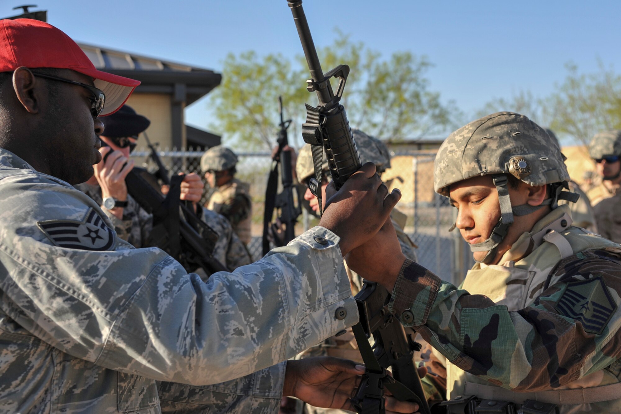 GOODFELLOW AIR FORCE BASE, Texas-- Staff Sgt. Alexander Williams, 17th Security Forces Squadron, hands an M-16 to Angelo State University ROTC Cadet Richard Torres during a field training exercise at Camp Sentinel April 6. Members of the 17th SFS aided in the training of the cadets and also provided the M-16s. (U.S. Air Force photo/ Airman 1st Class Michael Smith)