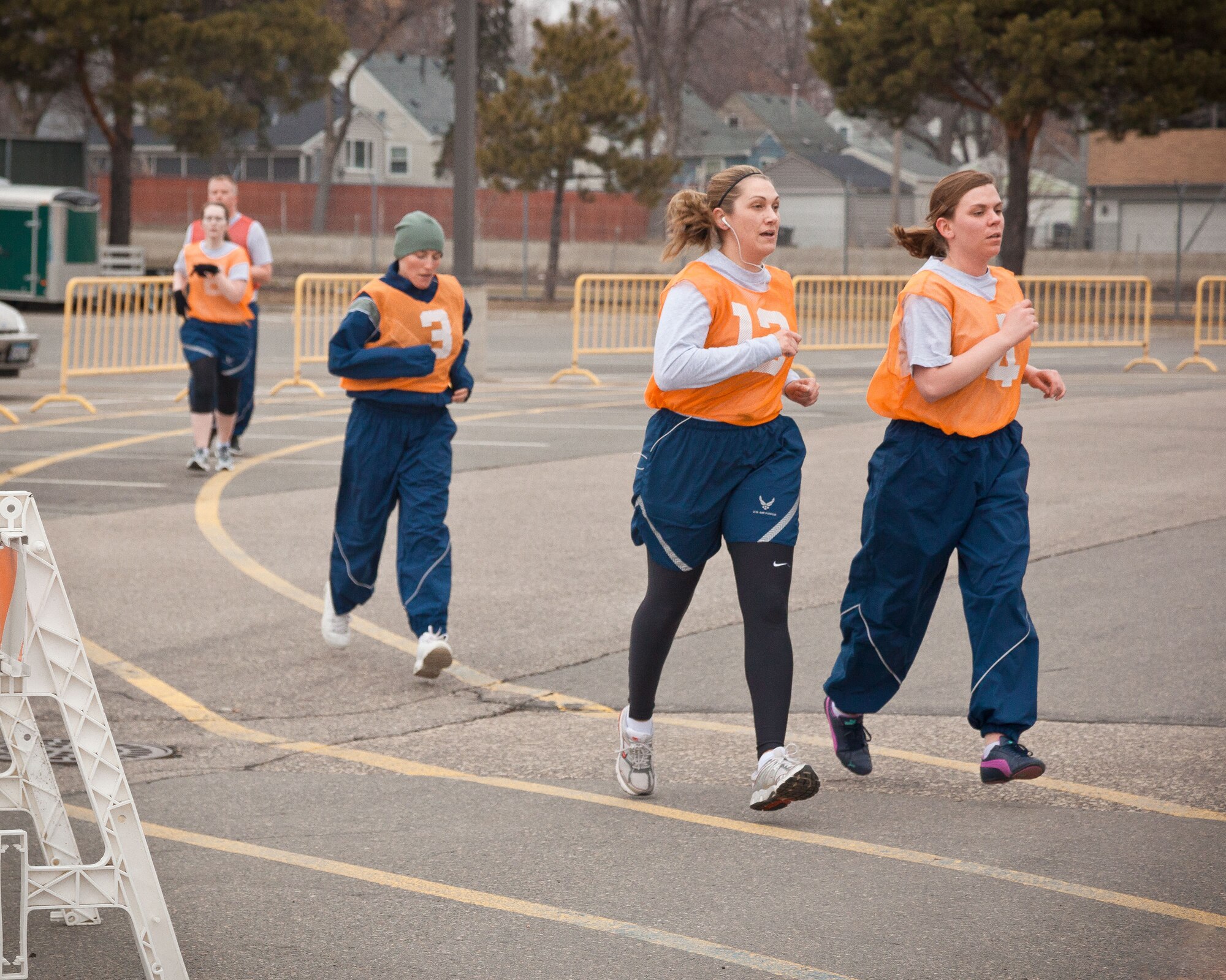Tech. Sgt. Dana Elliot (#12), and Senior Airman Kristen Suarez (#4), 934th Security Forces, make the corner on their final lap.  Airmen from the 934th Airlift Wing complete the running portion of their annual physical fitness assessment during the April Unit Training Assembly weekend at the Minneapolis-St. Paul Air Reserve Station, Minn.  (U.S. Air Force photo/Shannon McKay)