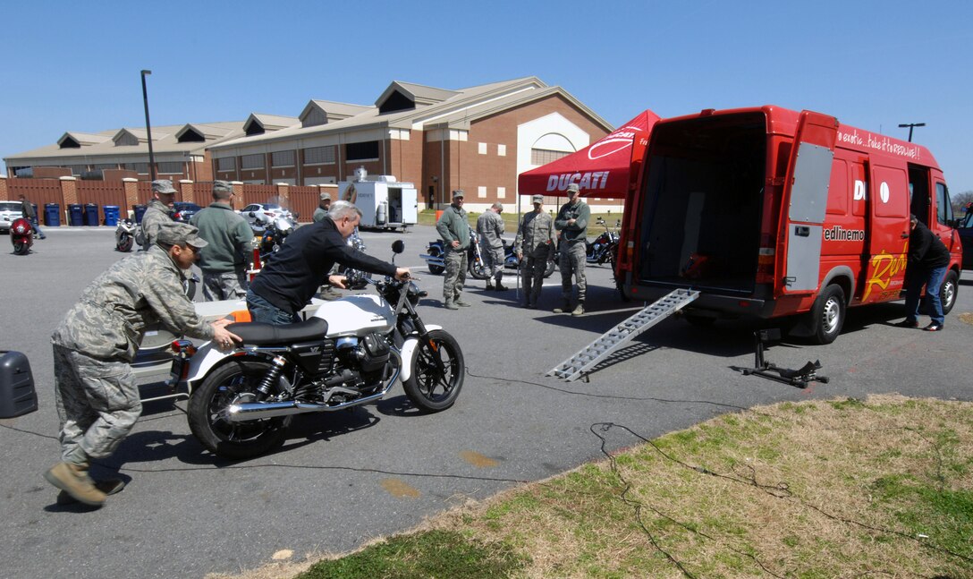 An Airman assigned to the 497th Intelligence, Surveillance and Reconnaissance Squadron and a representative from a motorcycle dealership wheel a motorcycle back onto a company truck after the second annual Sentinel Motorcycle Safety Show at Langley Air Force Base, Va., April 3, 2013. The show was hosted by the 497th ISR Group but was open to the entire Joint Base Langley-Eustis community. (U.S. Air Force photo by Staff Sgt. Jeff Nevison/Released)