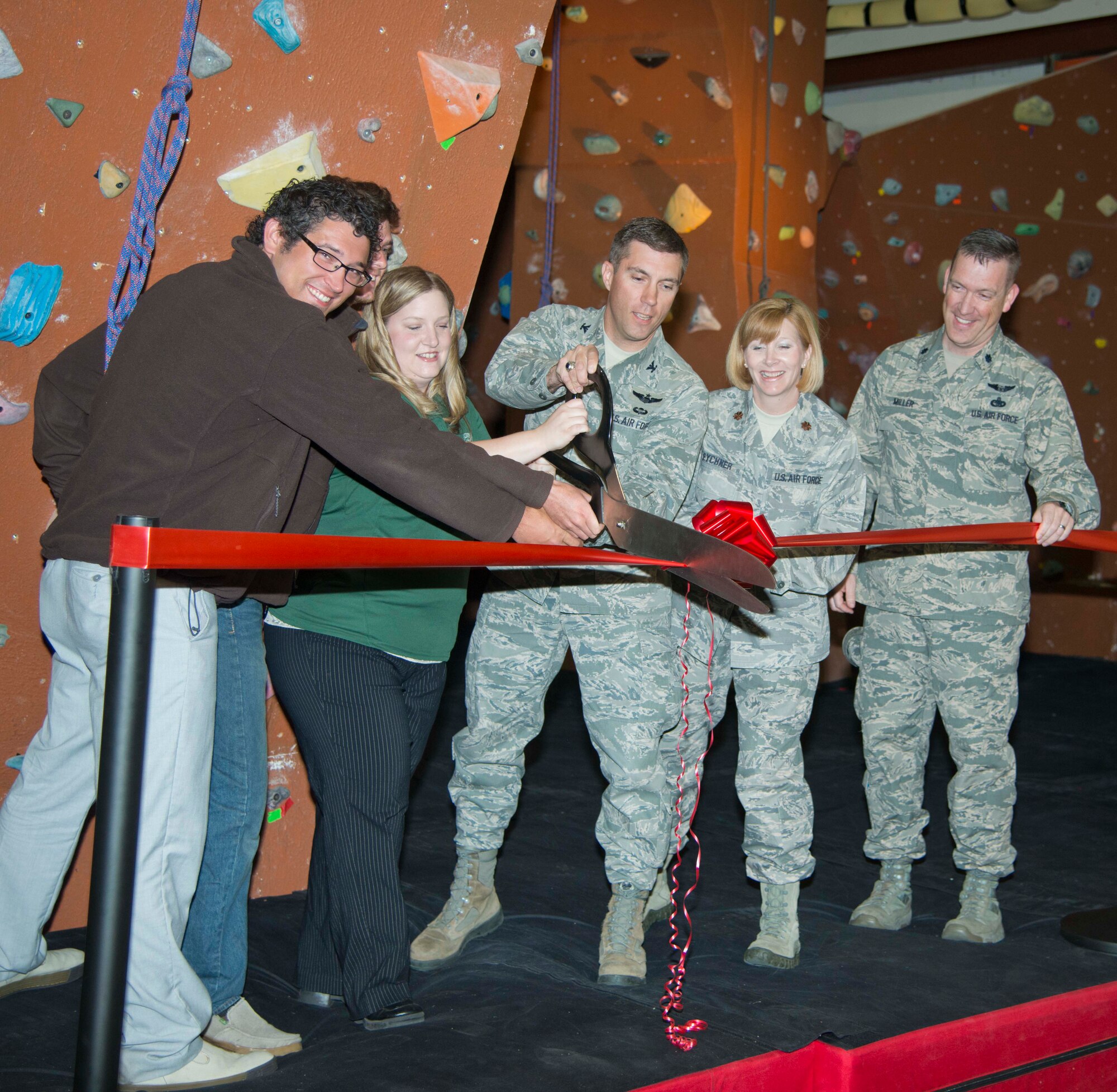 Col. John Klein, 60th Air Mobility Wing vice commander; Lt. Col. Cory Miller, 60th Mission Support Group deputy commander; Maj. Jonelle Eychner, 60th Force Support Squadron commander; Sonja Hunt, Outdoor Recreation manager; and volunteers who helped renovate the rock wall cut a ribbon Monday for the Outdoor Recreation rock wall at Travis. The wall expanded to 3,000 from 1,000 square feet of climbing surface. Additions include a new climbing tower, an overhang arch, an additional 4 feet in height and more roped climbs. The cushioning on the deck
was enhanced from a crushed-tire material to a safer double foam core material. (U.S. Air Force photo/Airman 1st Class Nicole Leidholm)