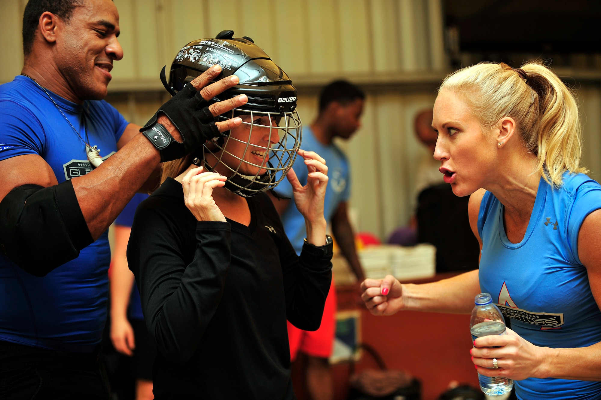 American Gladiators, Alex "Militia" Castro and Beth "Venom" Horn, prepare U.S. Air Force Col. Laura Lenderman, 380th Air Expeditionary Wing vice commander, for the Joust competition at an undisclosed location in Southwest Asia April 6, 2013. The Gladiators and Billy Blanks visited several bases in Southwest Asia during an Armed Forces Entertainment Fitness Tour. (U.S. Air Force photo by Tech. Sgt. Christina M. Styer/Released) 