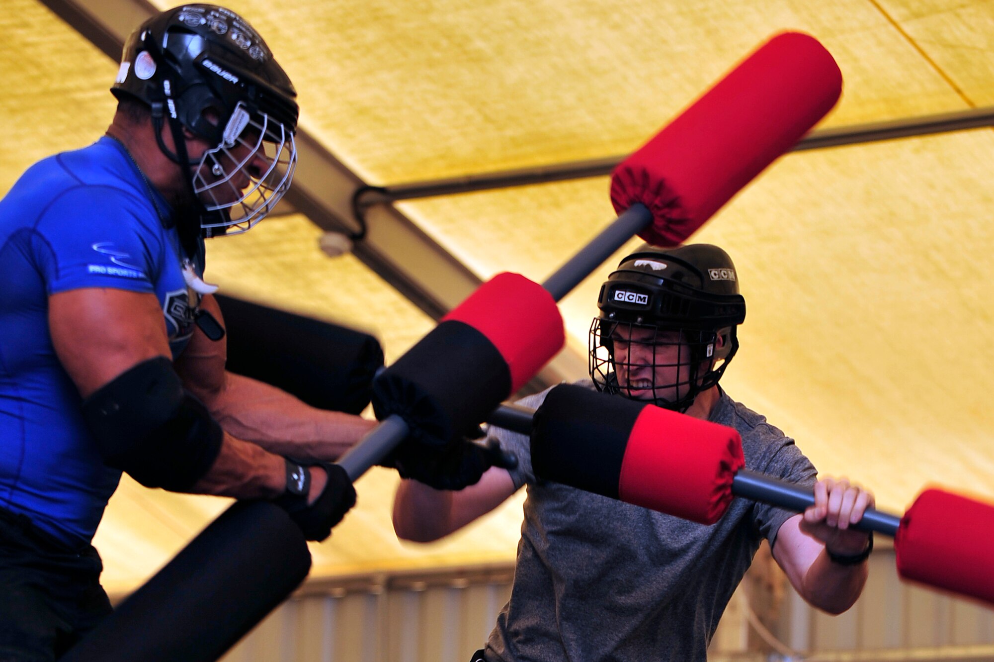 U.S. Air Force Staff Sgt. Josef Miller, 380th Expeditionary Civil Engineer Squadron explosive ordnance disposal technician, deployed from Andersen Air Force Base, Guam, competes against American Gladiator, Alex "Militia" Castro, during the Joust competition at an undisclosed location in Southwest Asia April 6, 2013. The Gladiators and Billy Blanks visited several bases in Southwest Asia during an Armed Forces Entertainment Fitness Tour. (U.S. Air Force photo by Tech. Sgt. Christina M. Styer/Released) 