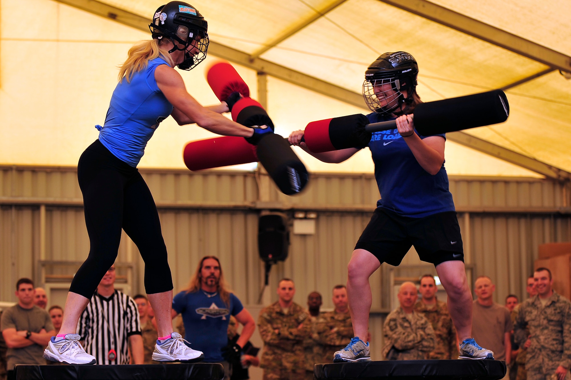 U.S. Air Force Staff Sgt. Tricia Briggs, 380th Expeditionary Operations Support Squadron weather forecaster, deployed from Luke Air Force Base, Ariz., competes against American Gladiator, Beth "Venom" Horn, during the Joust competition at an undisclosed location in Southwest Asia April 6, 2013. The Gladiators and Billy Blanks visited several bases in Southwest Asia during an Armed Forces Entertainment Fitness Tour. (U.S. Air Force photo by Tech. Sgt. Christina M. Styer/Released) 