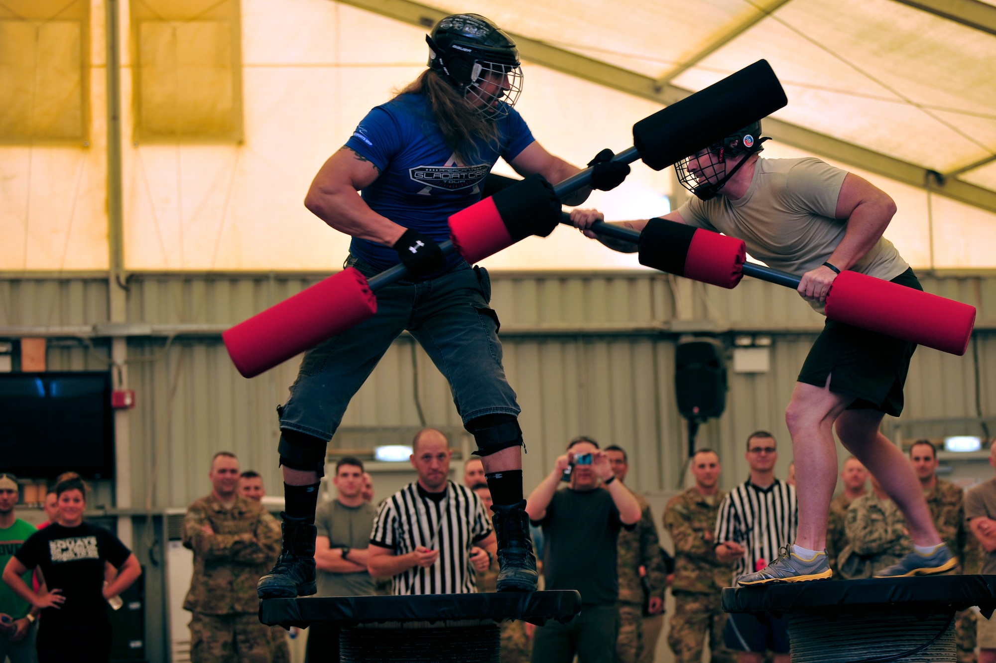 U.S. Air Force Staff Sgt. Todd Wycoff, 380th Expeditionary Civil Engineer Squadron explosive ordnance disposal technician, deployed from Dyess Air Force Base, Texas, competes against American Gladiator, Hollywood "Wolf" Yates, during the Joust competition at an undisclosed location in Southwest Asia April 6, 2013. The Gladiators and Billy Blanks visited several bases in Southwest Asia during an Armed Forces Entertainment Fitness Tour. (U.S. Air Force photo by Tech. Sgt. Christina M. Styer/Released) 