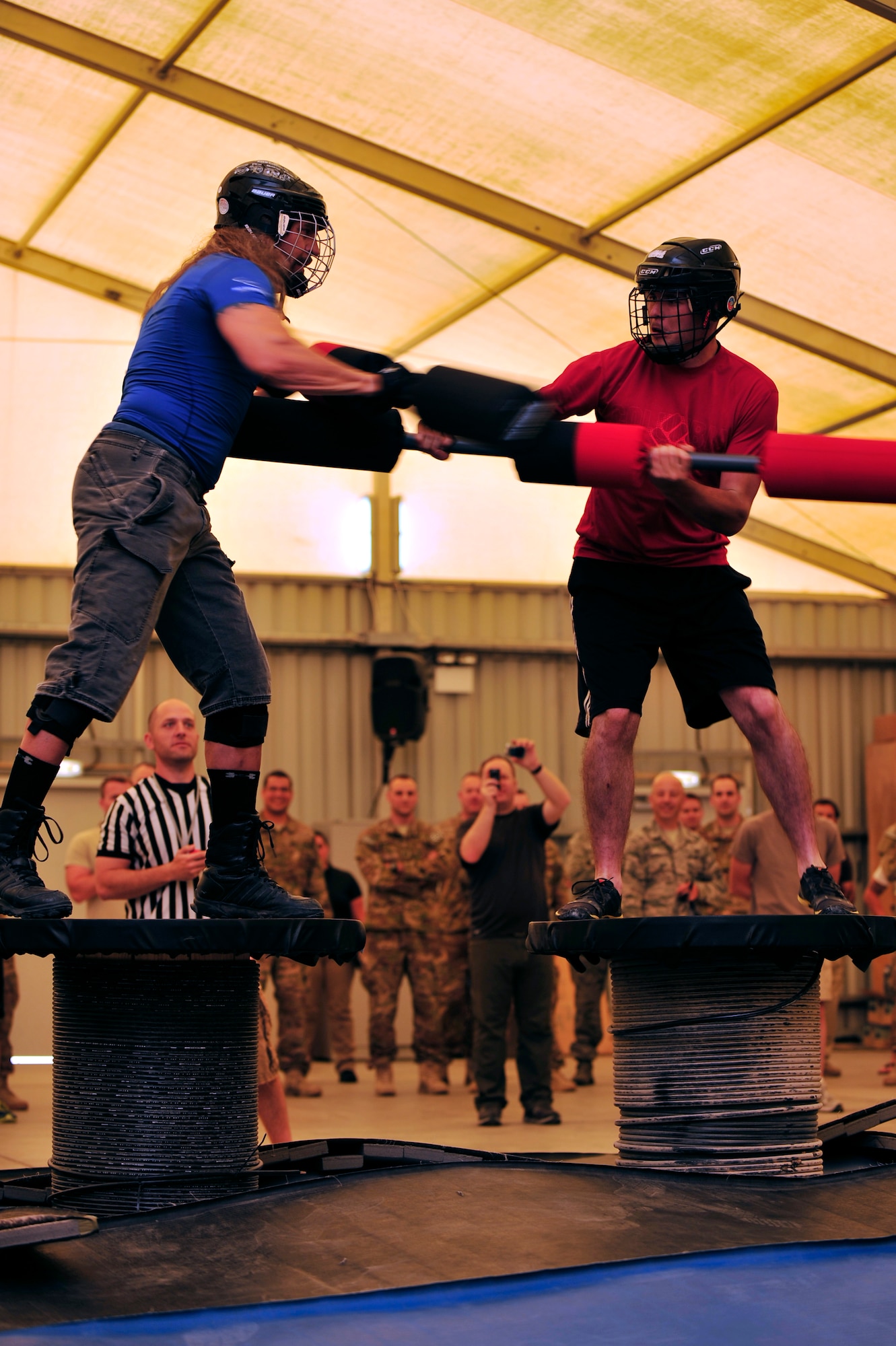 U.S. Air Force Senior Airman Desmond Longnecker, 380th Expeditionary Aircraft Maintenance Squadron crew chief, deployed from Kadena Air Base, Japan, competes against American Gladiator, Hollywood "Wolf" Yates, during the Joust competition at an undisclosed location in Southwest Asia April 6, 2013. The Gladiators and Billy Blanks visited several bases in Southwest Asia during an Armed Forces Entertainment Fitness Tour. (U.S. Air Force photo by Tech. Sgt. Christina M. Styer/Released) 