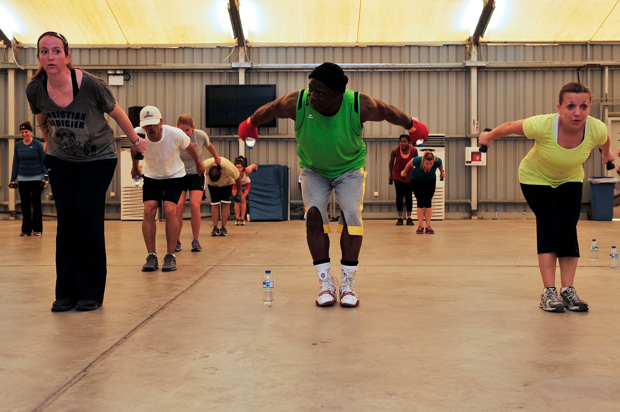 U.S. Air Force Master Sgt. Jaclyn MacKinley, 380th Air Expeditionary Wing command section support, and Tech. Sgt. Jennifer Japalucci, 380th Expeditionary Medical Group clinical operations flight chief, participate in a Tae Bo workout with creator Billy Blanks at an undisclosed location in Southwest Asia April 6, 2013. Blanks visited several bases in Southwest Asia with The American Gladiators during an Armed Forces Entertainment Fitness Tour. (U.S. Air Force photo by Tech. Sgt. Christina M. Styer/Released) 