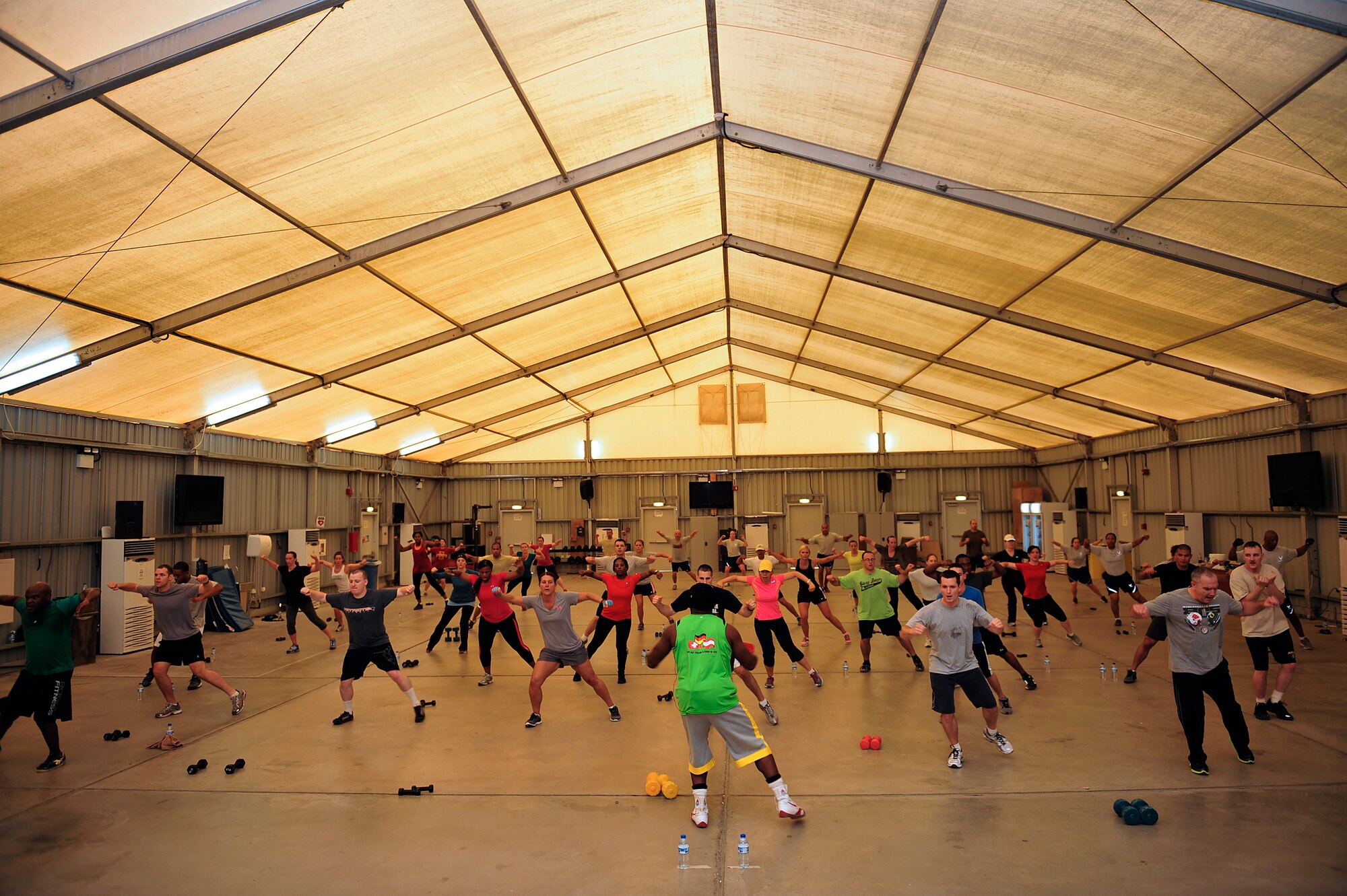 Members of the 380th Air Expeditionary Wing participate in a Tae Bo workout with creator Billy Blanks at an undisclosed location in Southwest Asia April 6, 2013. Blanks visited several bases in Southwest Asia with The American Gladiators during an Armed Forces Entertainment Fitness Tour. (U.S. Air Force photo by Tech. Sgt. Christina M. Styer/Released) 
