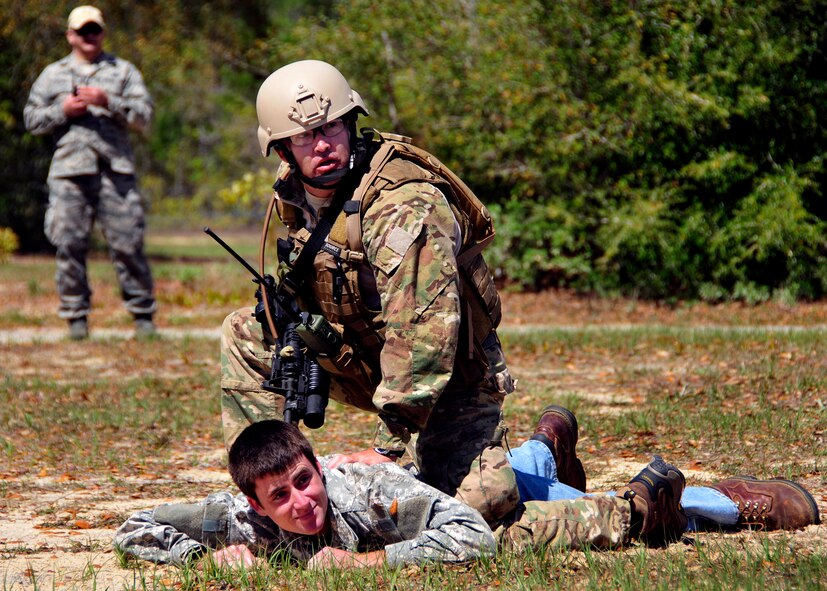Senior Airman Bryan Poole, of the 919th Security Forces Squadron, restrains Trainee Brian Gaithera, of the Development and Training Program, hostile member of the local nationals during an extraction exercise at Duke Field, Fla., April 6. The Security Forces Airmen executed this training exercise with the trainees from the Development and Training Program. The DTP is an Air Force Reserve Command introductory program to help recruits prepare for military life prior to going to basic military training. The trainees were given a first-hand view of the procedures performed to recover American personnel from a downed aircraft in a hostile environment. They were able to participate as local nationals and the missing American personnel. (U.S. Air Force photo/Tech. Sgt. Cheryl L. Foster)