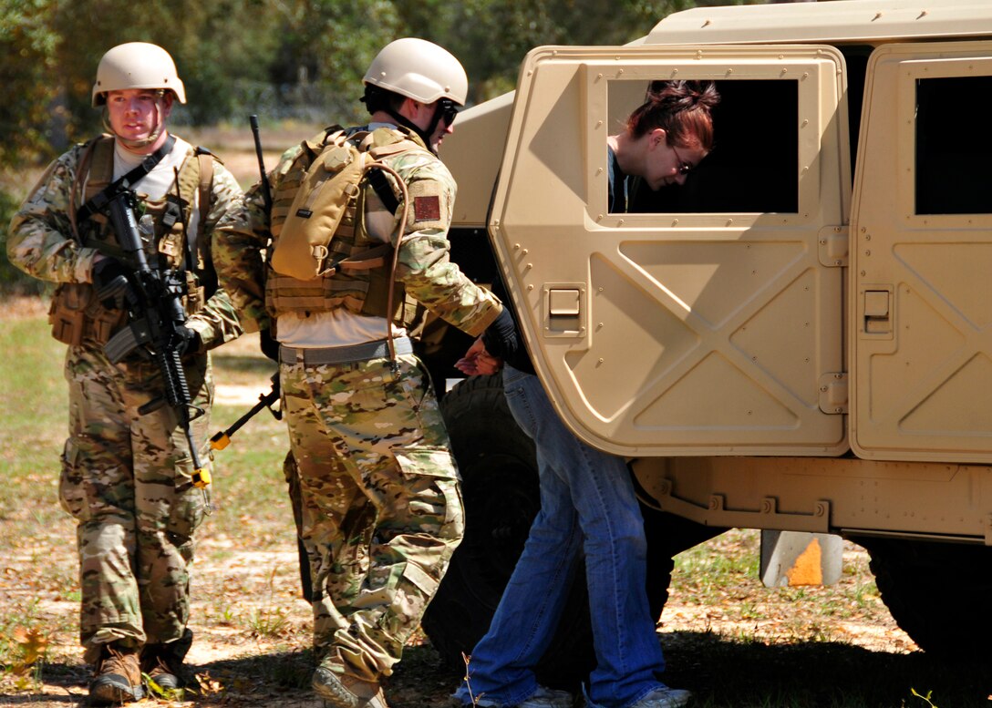 Staff Sgt. Thomas Maloney, of the 919th Security Forces Squadron, guides Trainee Dawn Hoalt, of the Development and Training Program, into a HMMWV during an extraction exercise at Duke Field, Fla., April 6. The Security Forces Airmen executed this training exercise with the trainees from the Development and Training Program. The DTP is an Air Force Reserve Command introductory program to help recruits prepare for military life prior to going to basic military training. The trainees were given a first-hand view of the procedures performed to recover American personnel from a downed aircraft in a hostile environment. They were able to participate as local nationals and the missing American personnel. (U.S. Air Force photo/Tech. Sgt. Cheryl L. Foster) 